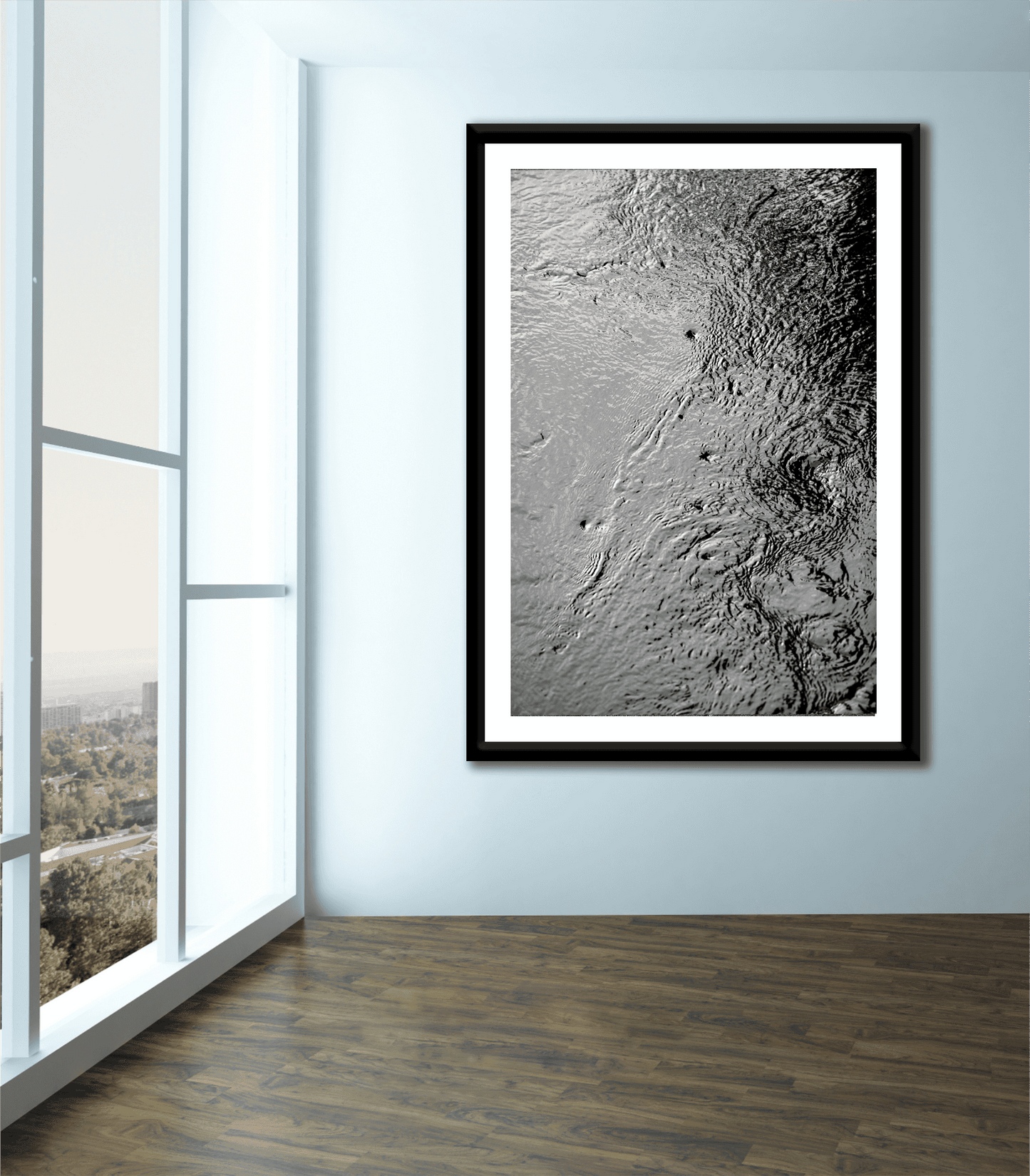 Large framed Traces #5 – Currents and Whirlpools in a Maine Stream – Black & White Nature Photography displayed in a bright, modern room with floor-to-ceiling windows.