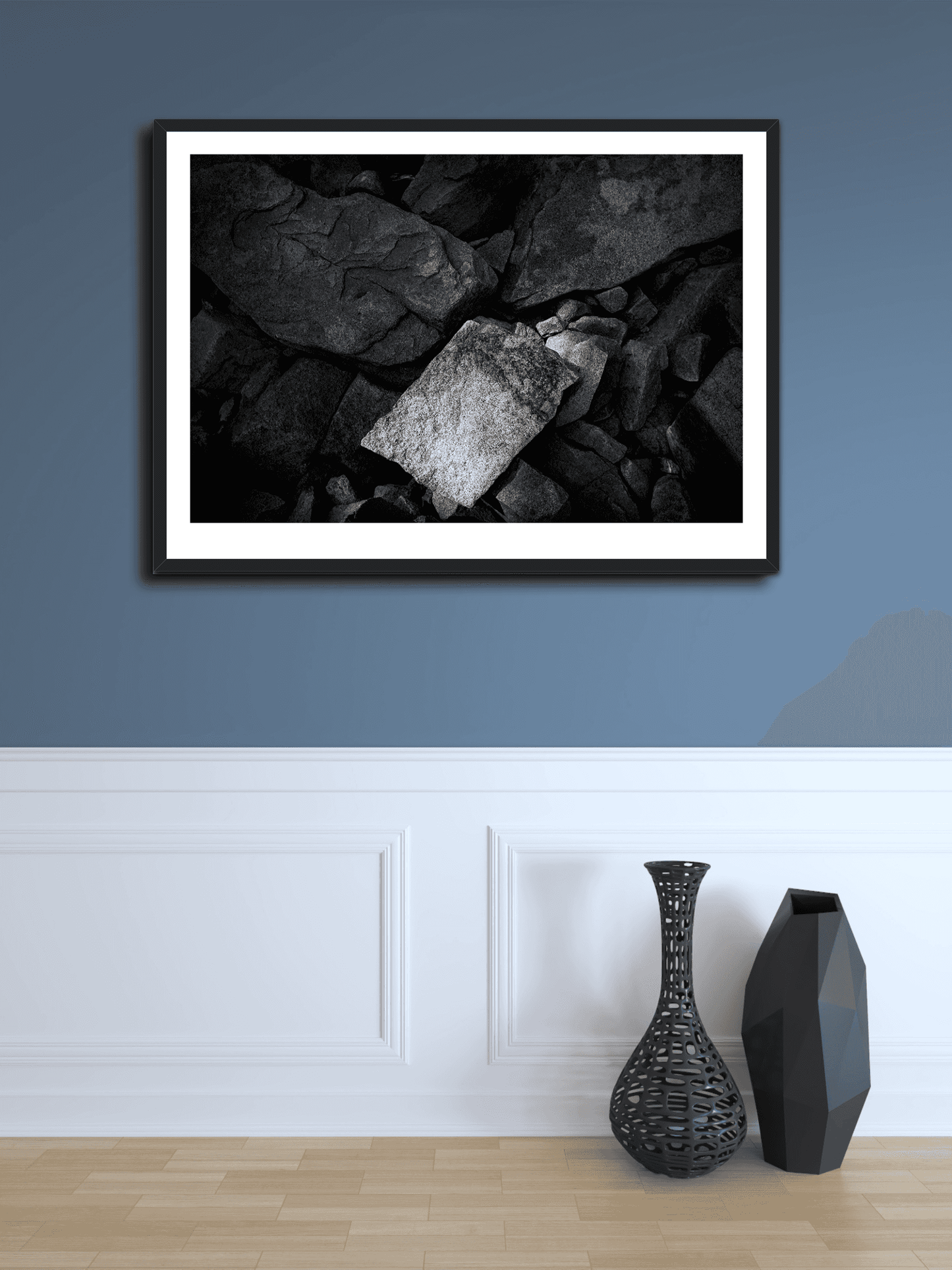 Black and white abstract rock photo 'Front and Center' framed and mounted on a blue accent wall above decorative vases in a stylish home interior.