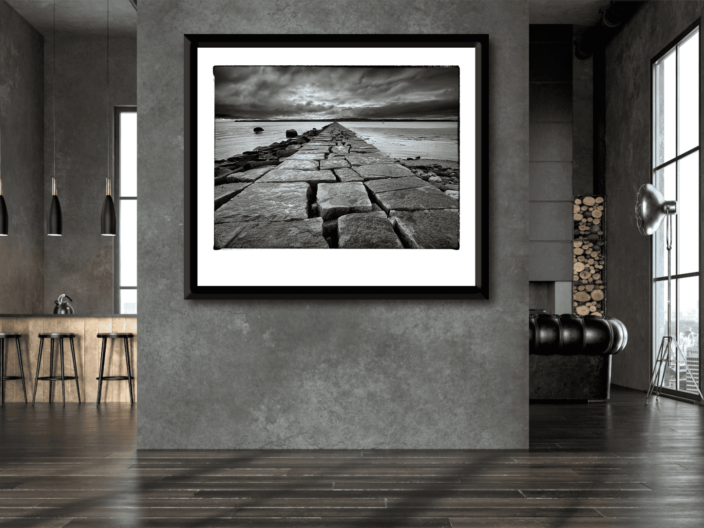 Breakwater, Rockland ME – Award-Winning Black & White iPhone Photo, Limited Edition Print displayed in modern interior with moody seascape. Dramatic granite jetty leads into Rockland Harbor under stormy skies, ideal for fine art collectors and interior designers.
