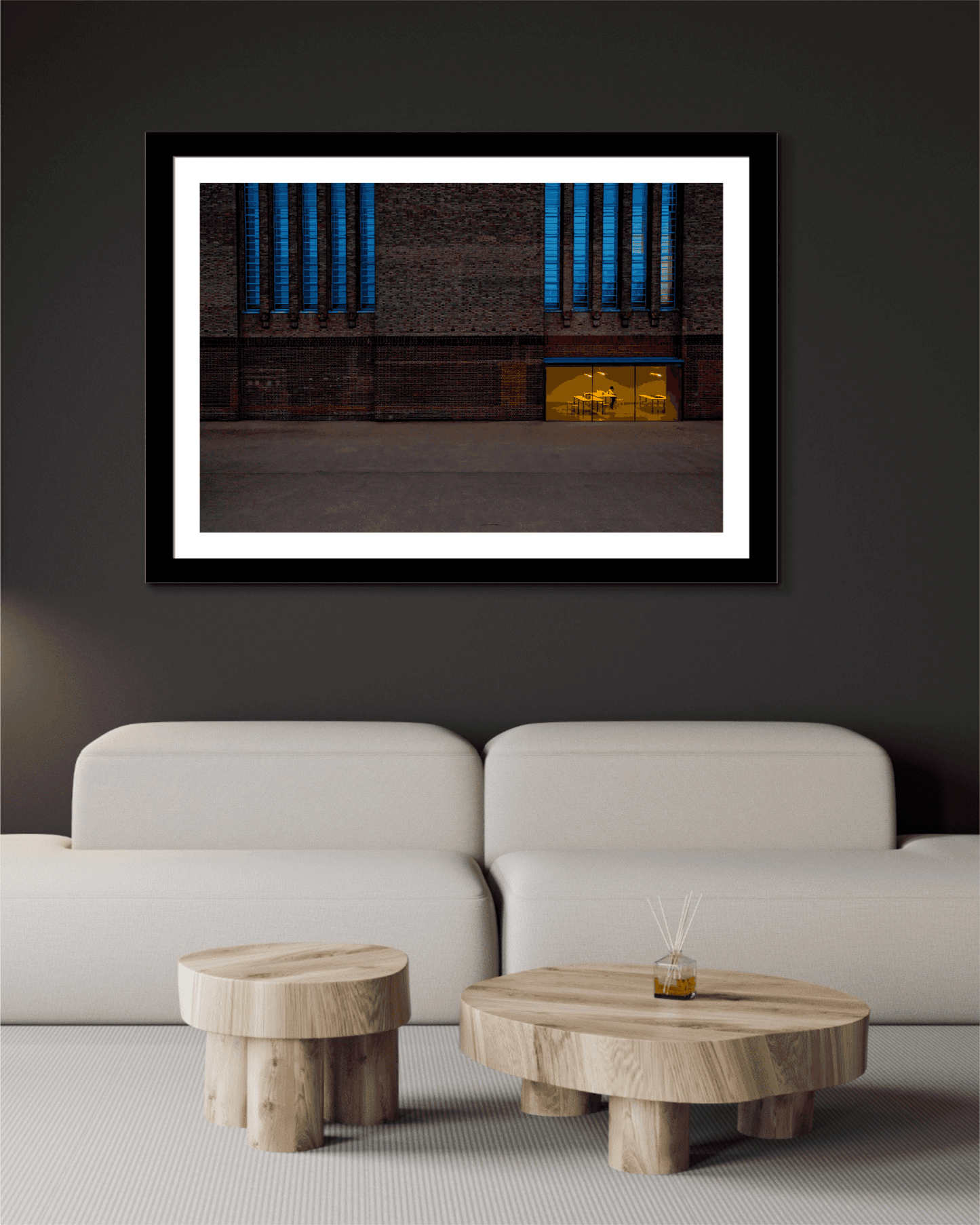 The Tate Modern – A Study in Color and Line framed in black and white matting, showcased above a minimalist white sofa in a modern living room setting.