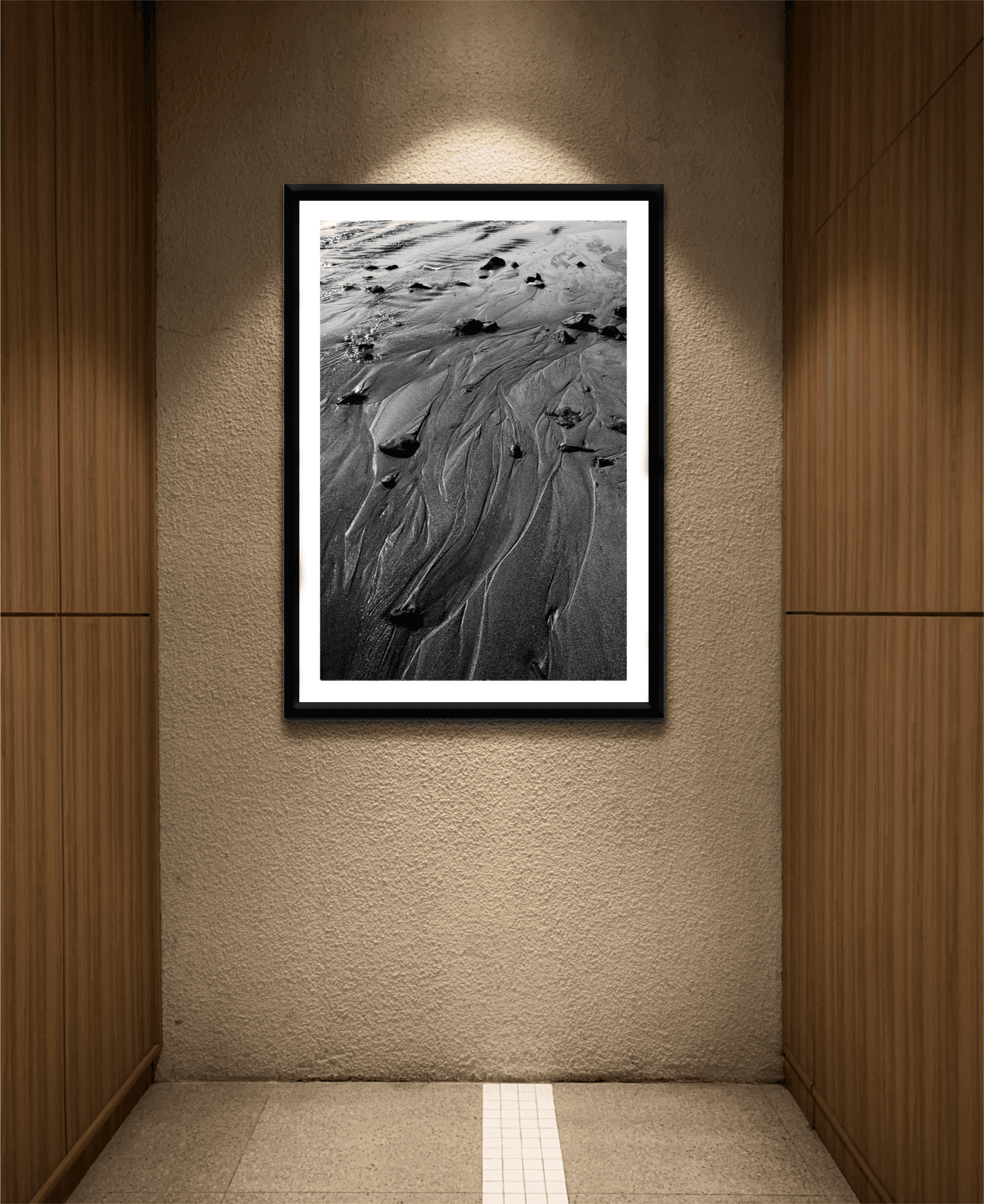 'Traces #3' black and white sand pattern print elegantly framed in a softly lit hallway, ideal for minimalist and nature-themed decor.