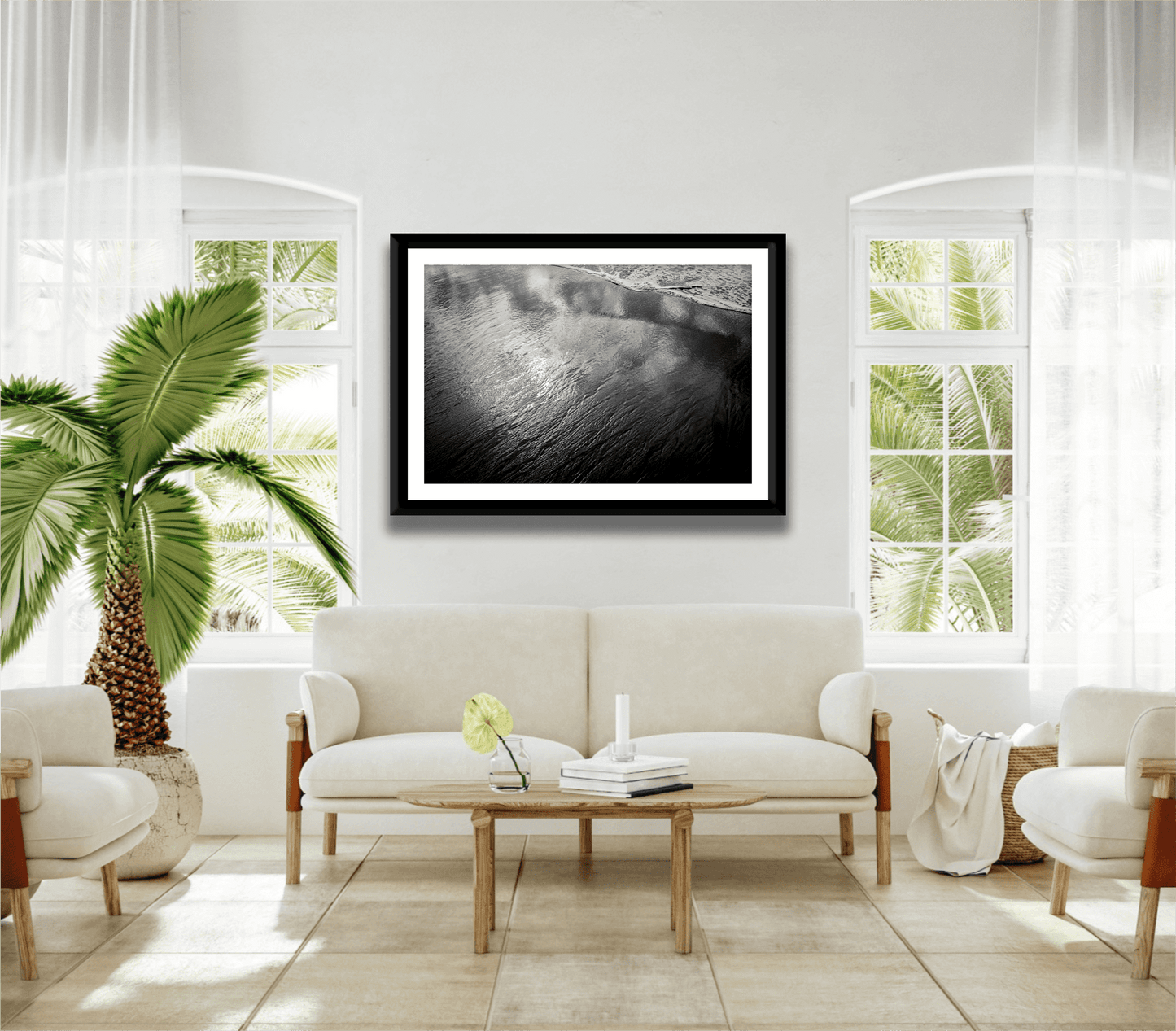 Framed 'Traces #4 – Reflections at the Sea Edge, Maine' black and white seascape in bright living room with tropical decor and natural light.