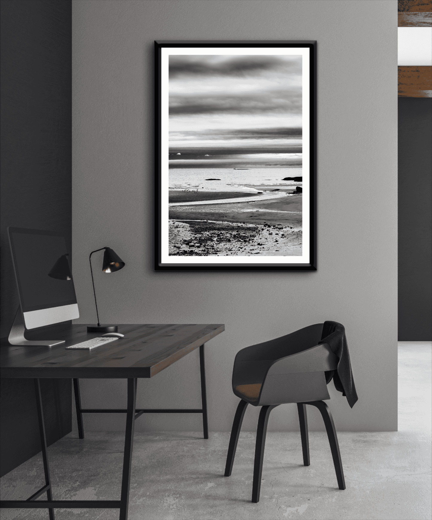 A print of a moody black and white image titled Grey Atlantic #1, moody coastal Maine image shown framed on the wall of a room setting