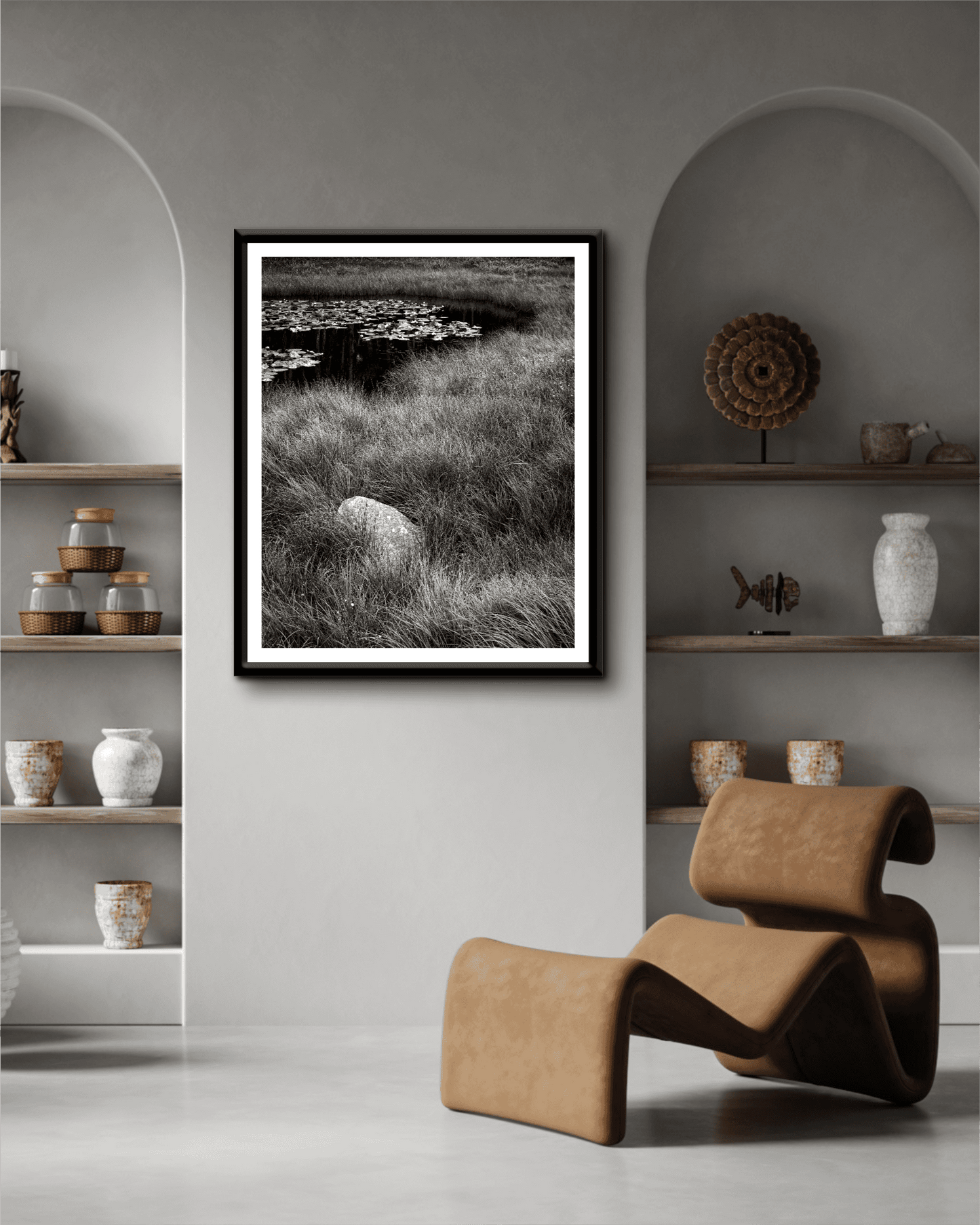Elegant wall art display of 'Pond Boulder' Wyoming nature print in a modern home with arched shelving and earthy decor elements.