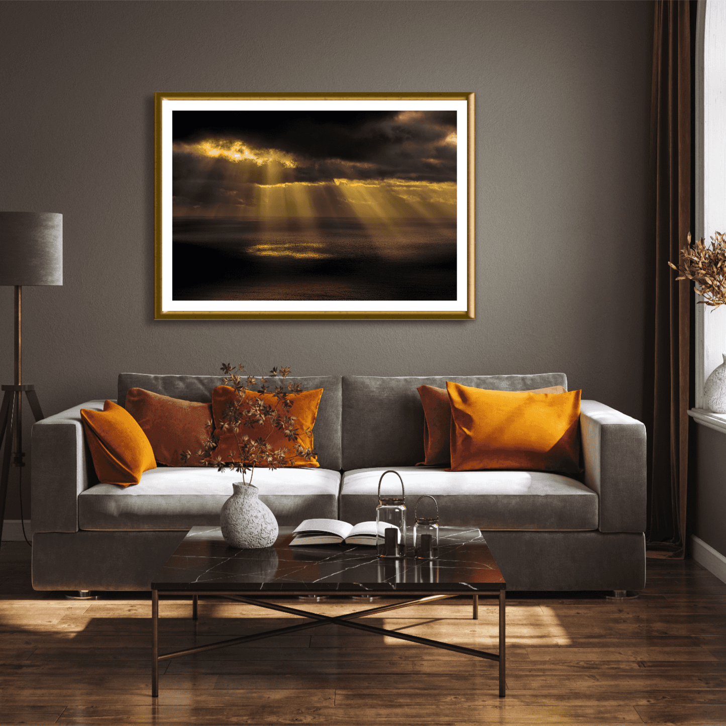 Elegant living room with gold-framed Ring of Light sunrise print, complementing warm-toned pillows and dark wood furniture.