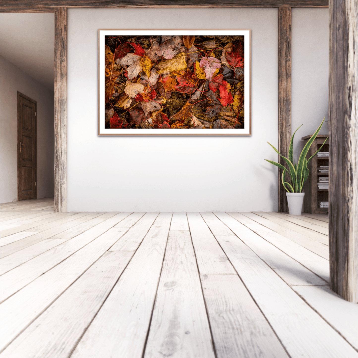 Autumn Leaves Collage – Limited Edition Fine Art Fall Photograph from West Virginia displayed in a rustic modern interior with wood beams and white walls. Vibrant fallen leaves in red, orange, and yellow tones create a striking seasonal focal point for home decor.