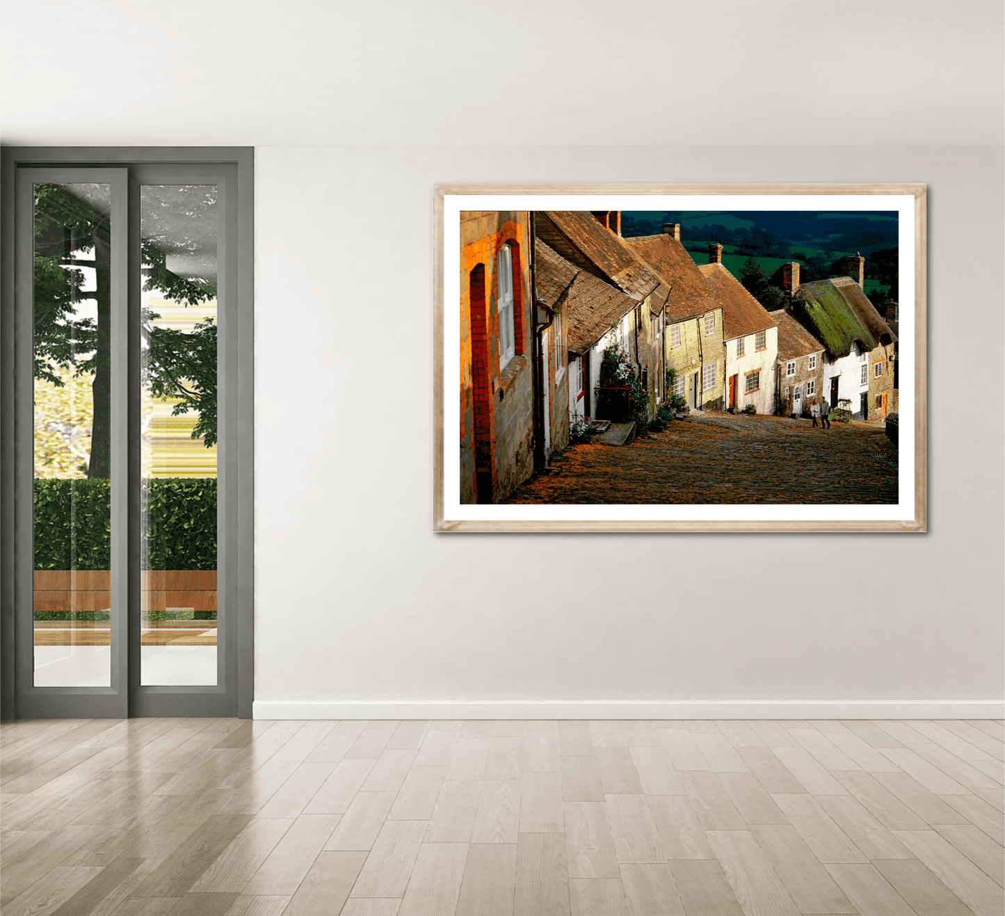 Gold Hill, Shaftesbury – A Fairy Tale Scene in Dorset large framed print showcased in a modern room with wooden flooring and glass doors.