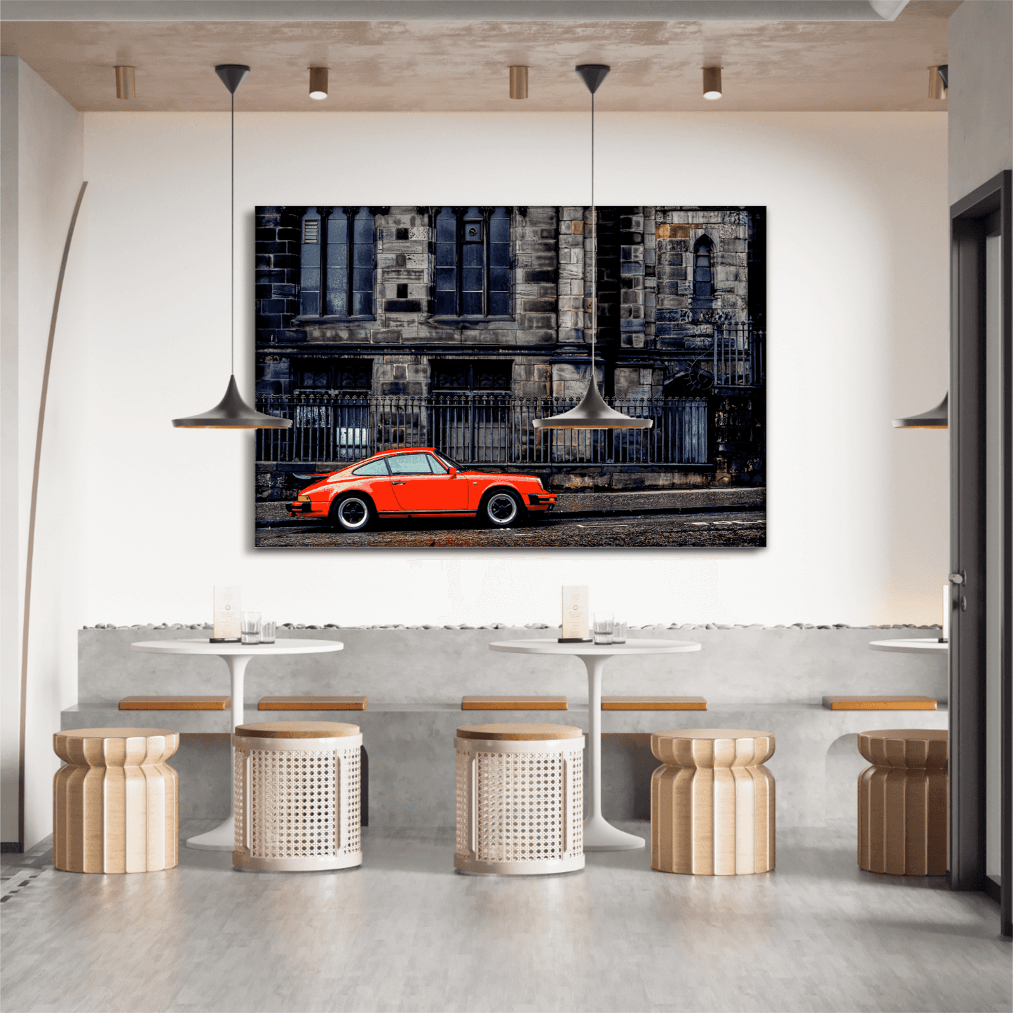 Urban composition print of red Porsche in Edinburgh, displayed in a modern café interior with pendant lighting and neutral tones.