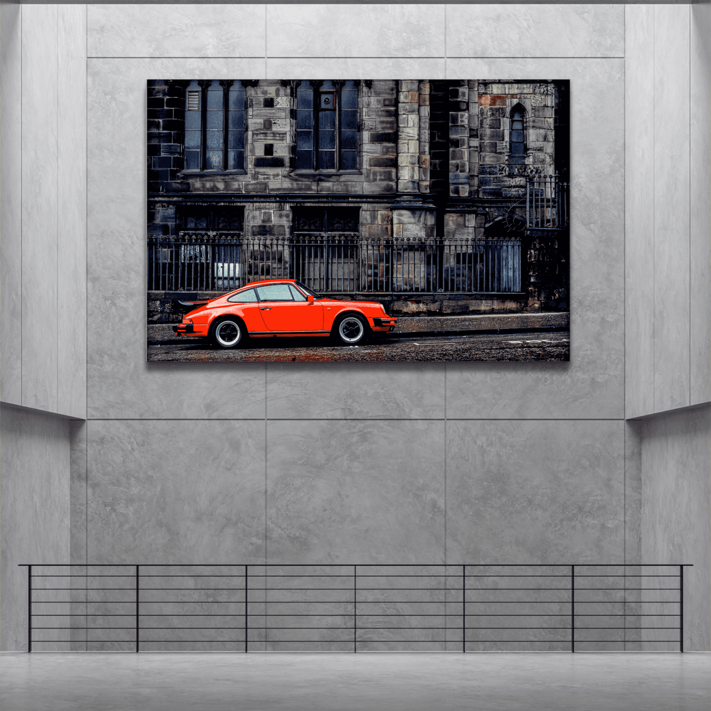 Limited edition wall art print of a red Porsche in front of Edinburgh cathedral, displayed in a modern concrete gallery space.