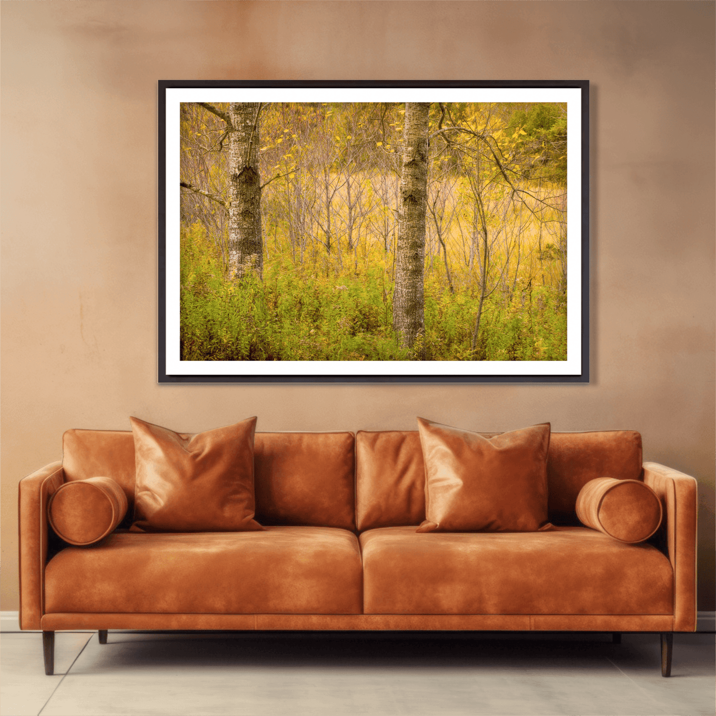 Golden Woods autumn forest photograph framed above a leather sofa, enhancing interior decor with warm fall colors and serene woodland composition.