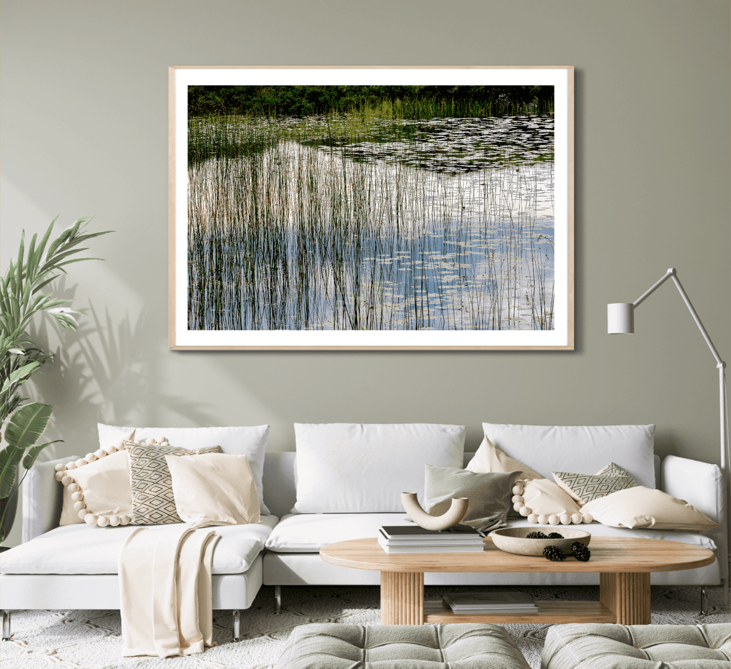 Lochinver landscape photography print framed above a modern white sofa, bringing calming Scottish nature to contemporary living room decor.