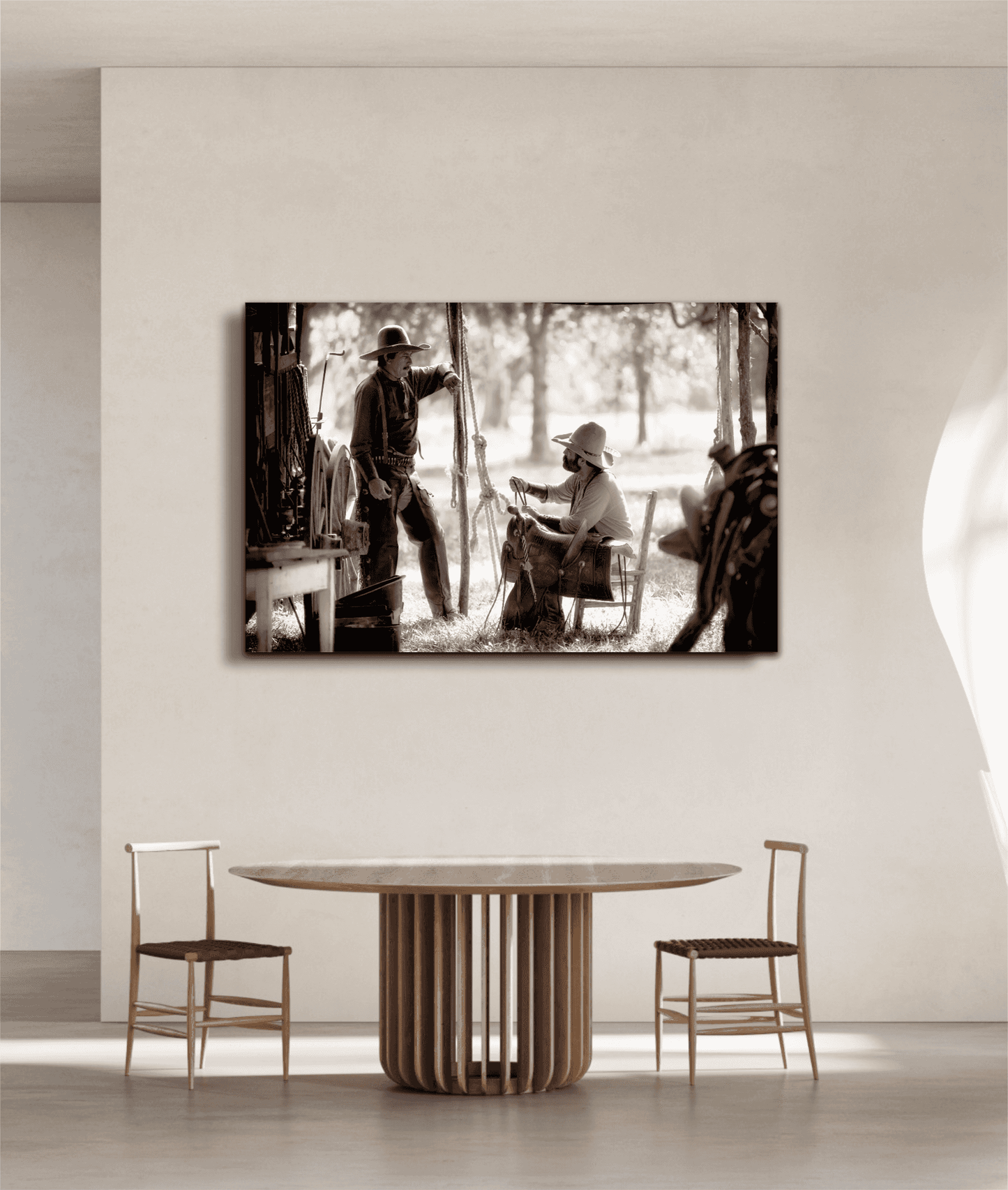 Western fine art print 'Camp Talk: A Chuckwagon Cook-Off in Authentic Old West Style' mounted in a bright dining space with neutral tones and minimalist wooden furniture.