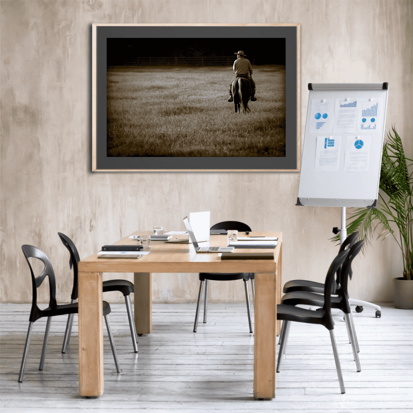 Western cowboy artwork titled The Lone Rider framed in a rustic meeting room. Sepia fine art print of Texas ranch life on display.