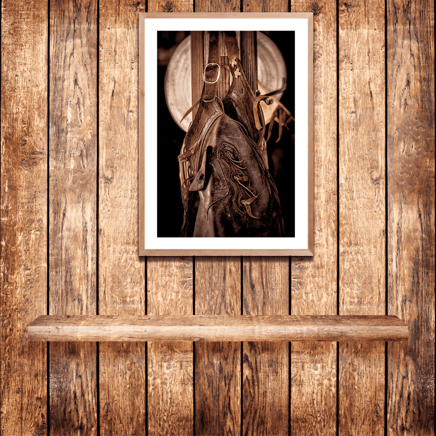 Framed sepia-toned cowboy tack print mounted on a wooden wall, enhancing rustic Western interior design with Texas ranch photography.