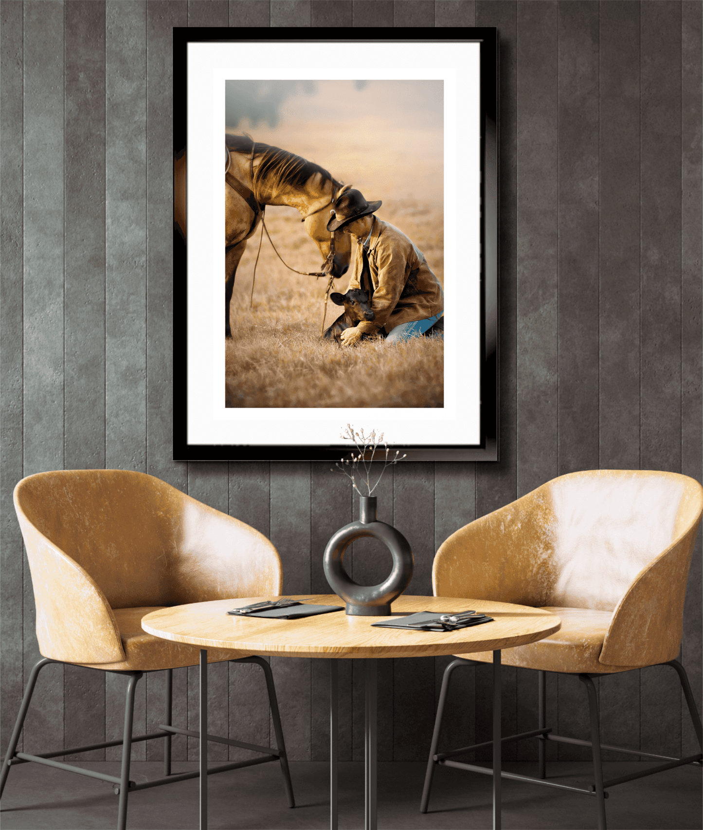 Limited edition cowboy and calf print in black frame above a cozy dining nook, blending Western heritage with contemporary interior design.