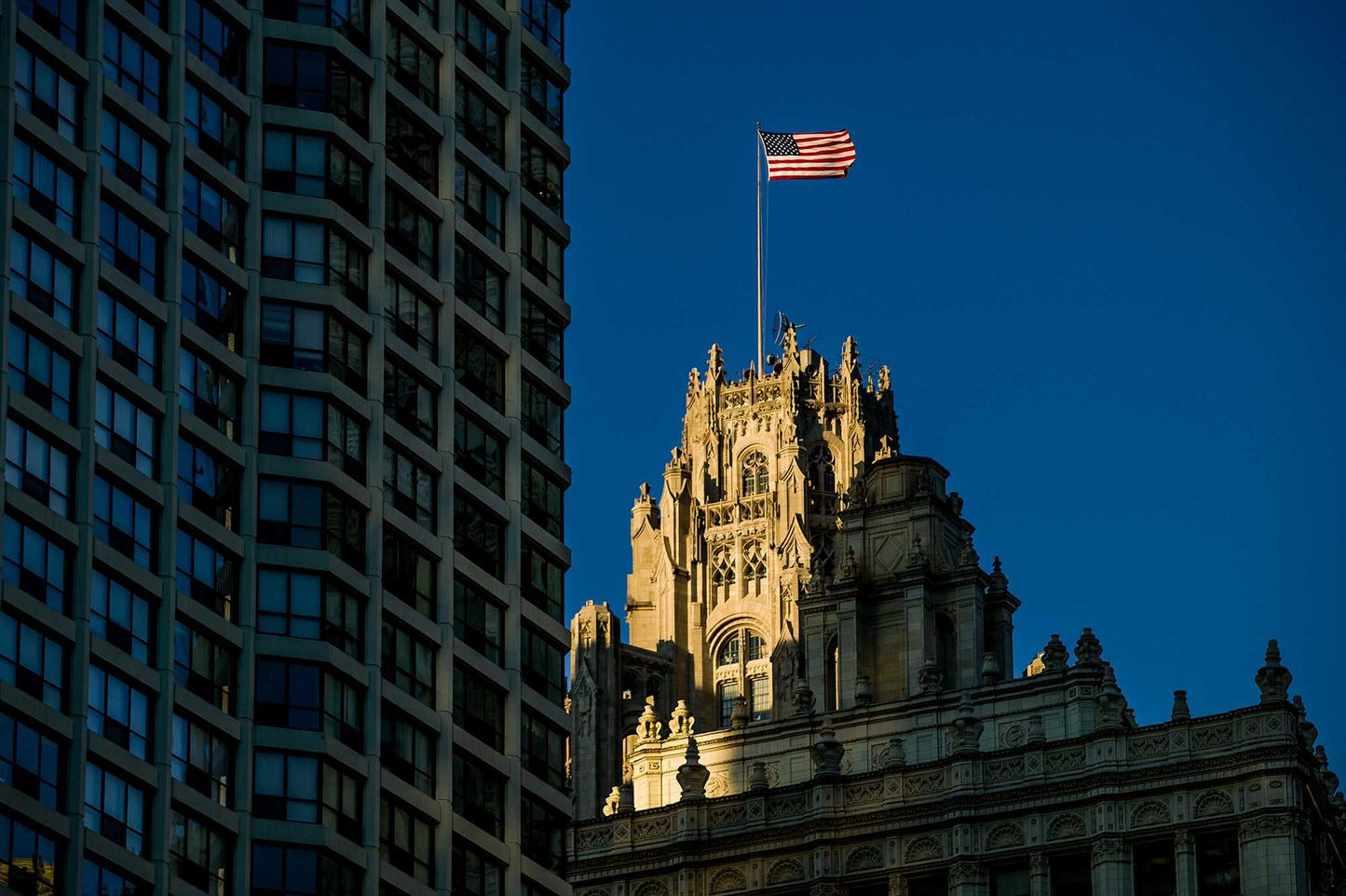 Chicago Tribune Tower image with American flag glowing in summer light against deep blue sky. Limited edition fine art photo by Michael Hart.
