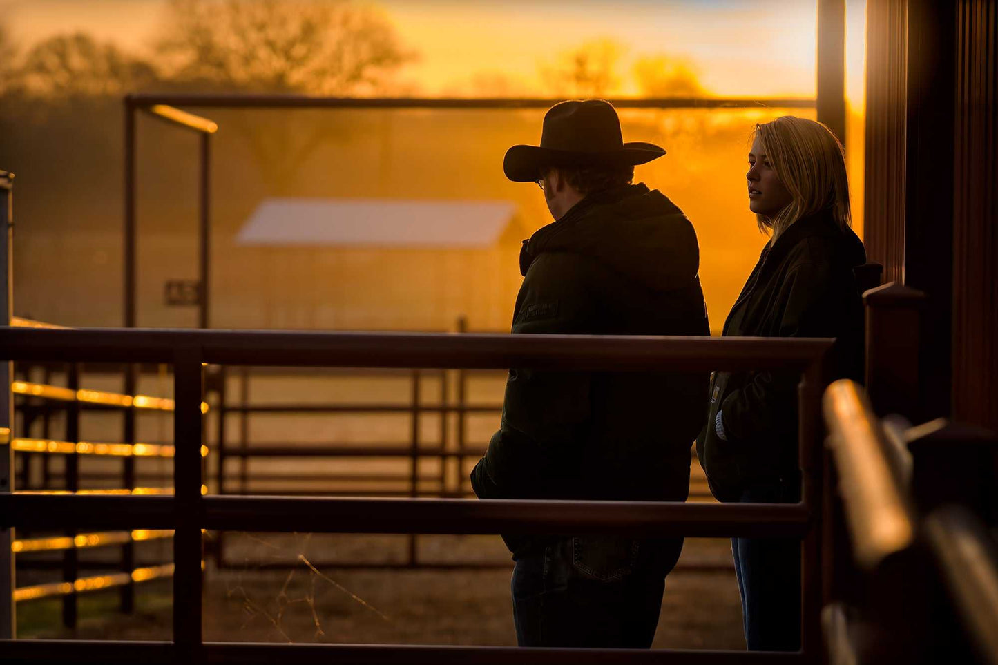 Corral Sunrise: Ranch Hands at Daybreak in Golden Light fine art print showing two cowboys in warm sunrise tones, ideal for Western decor themes.