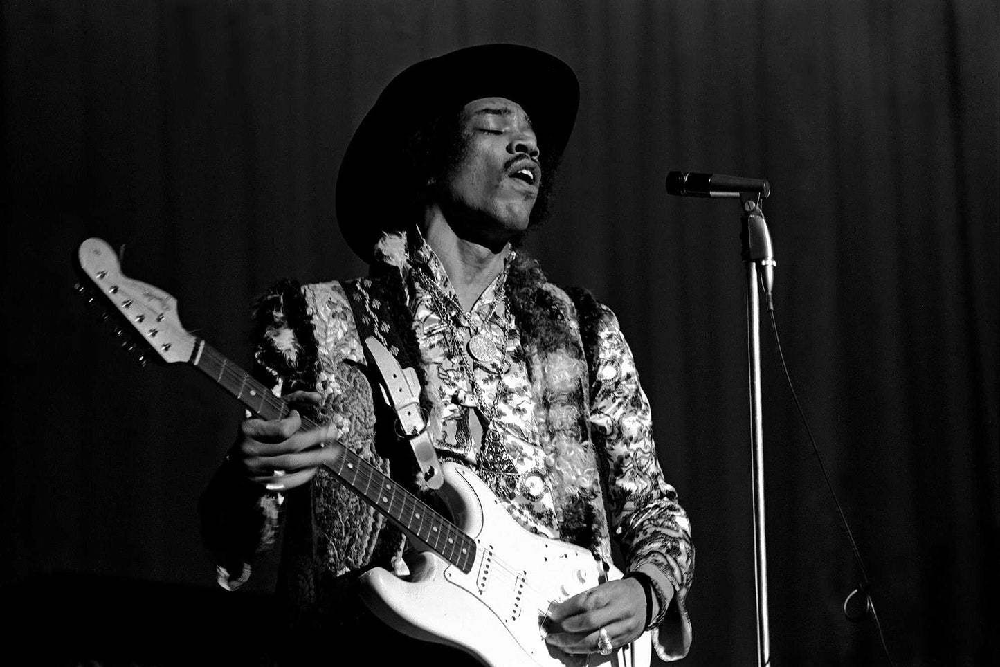 Iconic black and white image of Jimi Hendrix performing live in Houston, 1968, playing guitar mid-song. A must-have fine art print for music lovers.