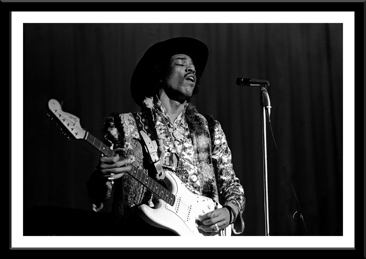Close-up of framed iconic Jimi Hendrix black and white photo from 1968 Houston concert. A striking visual artwork for collectors and fans.
