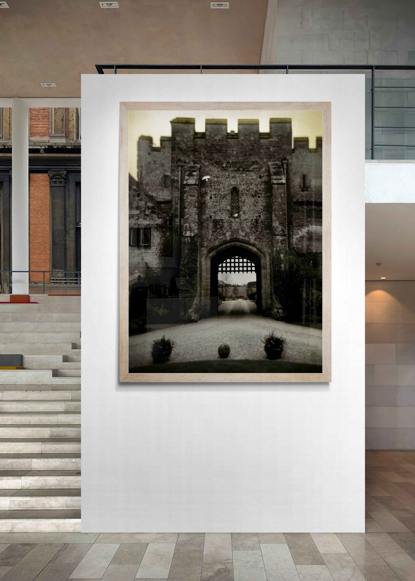 Amberley Gate – Limited Edition Fine Art Photograph displayed in a modern gallery setting. Showcases the historic English castle gate in warm tones.
