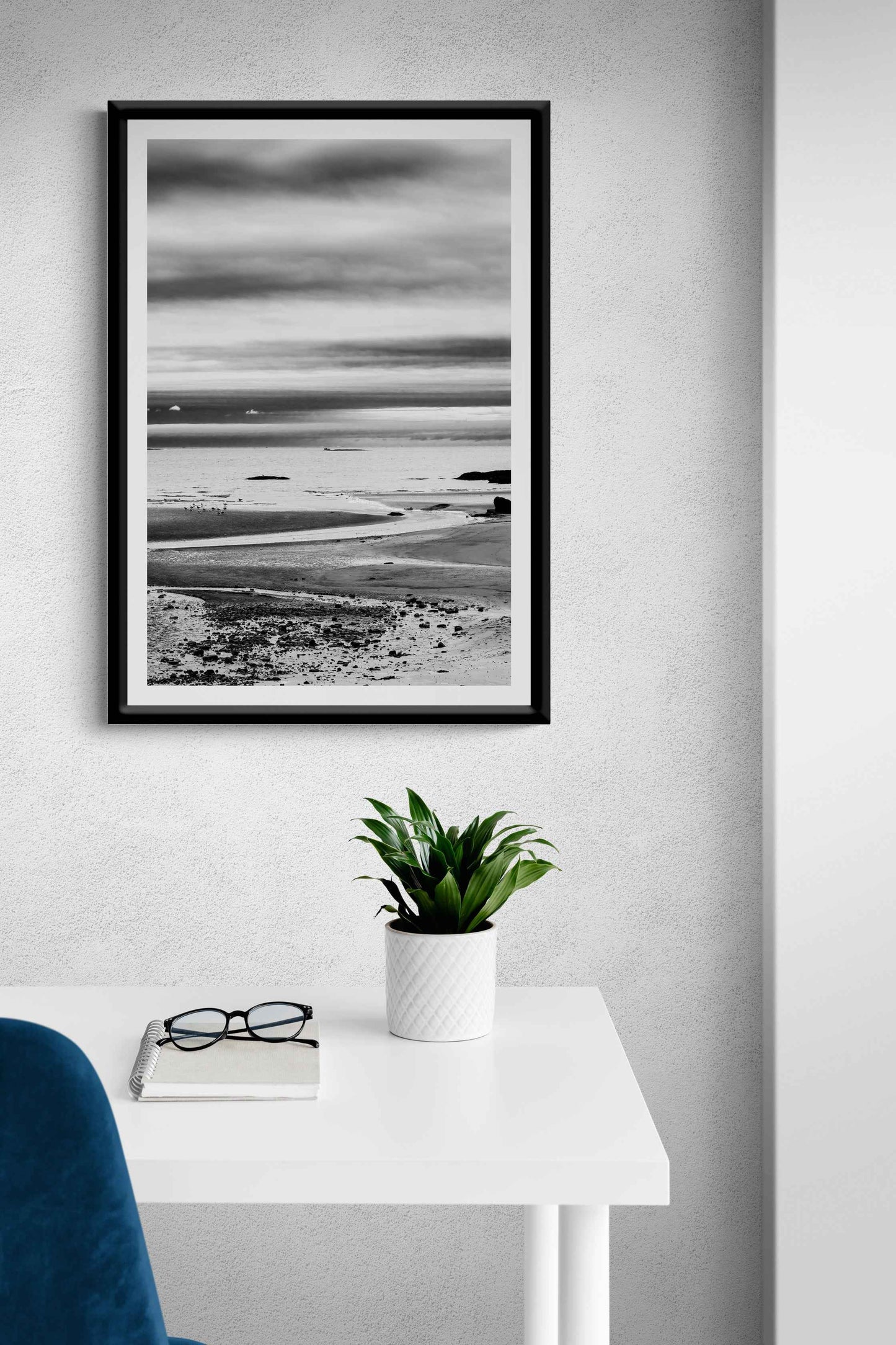 A print of a moody black and white image titled Grey Atlantic #1, moody coastal Maine image shown framed on the wall of a room setting