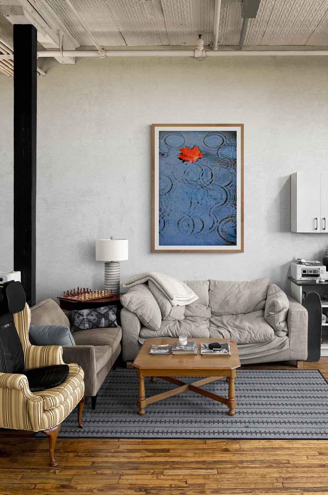 Autumn Rain – Limited Edition Fine Art Photograph hung in a rustic living room. The red leaf and blue water add contrast and calm to the space.