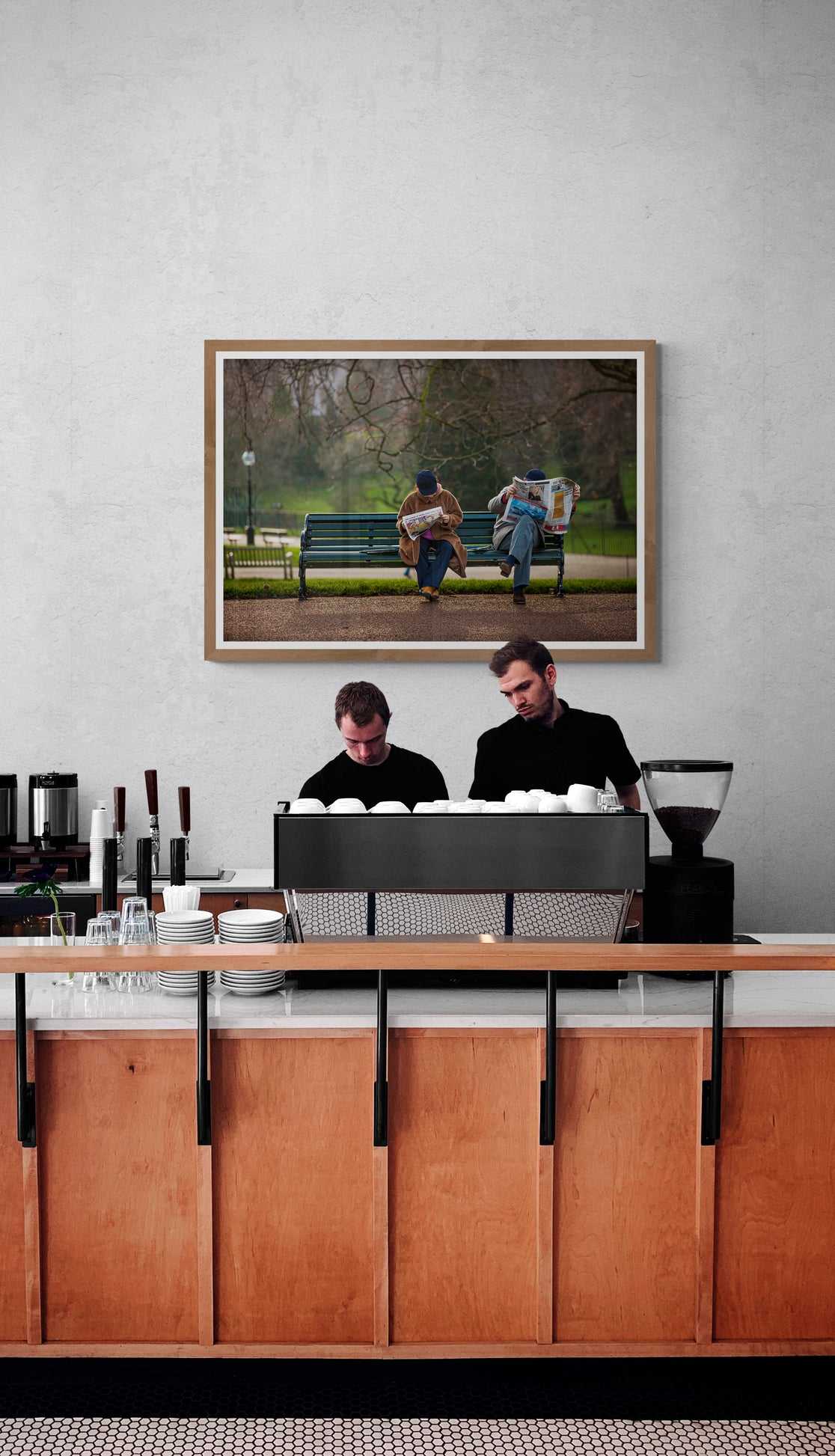 The Saturday News – A Photograph of Couple Captured in Hyde Park hung above a café counter. A London urban serenity print enhancing the ambiance of commercial interiors with quiet moments photography.
