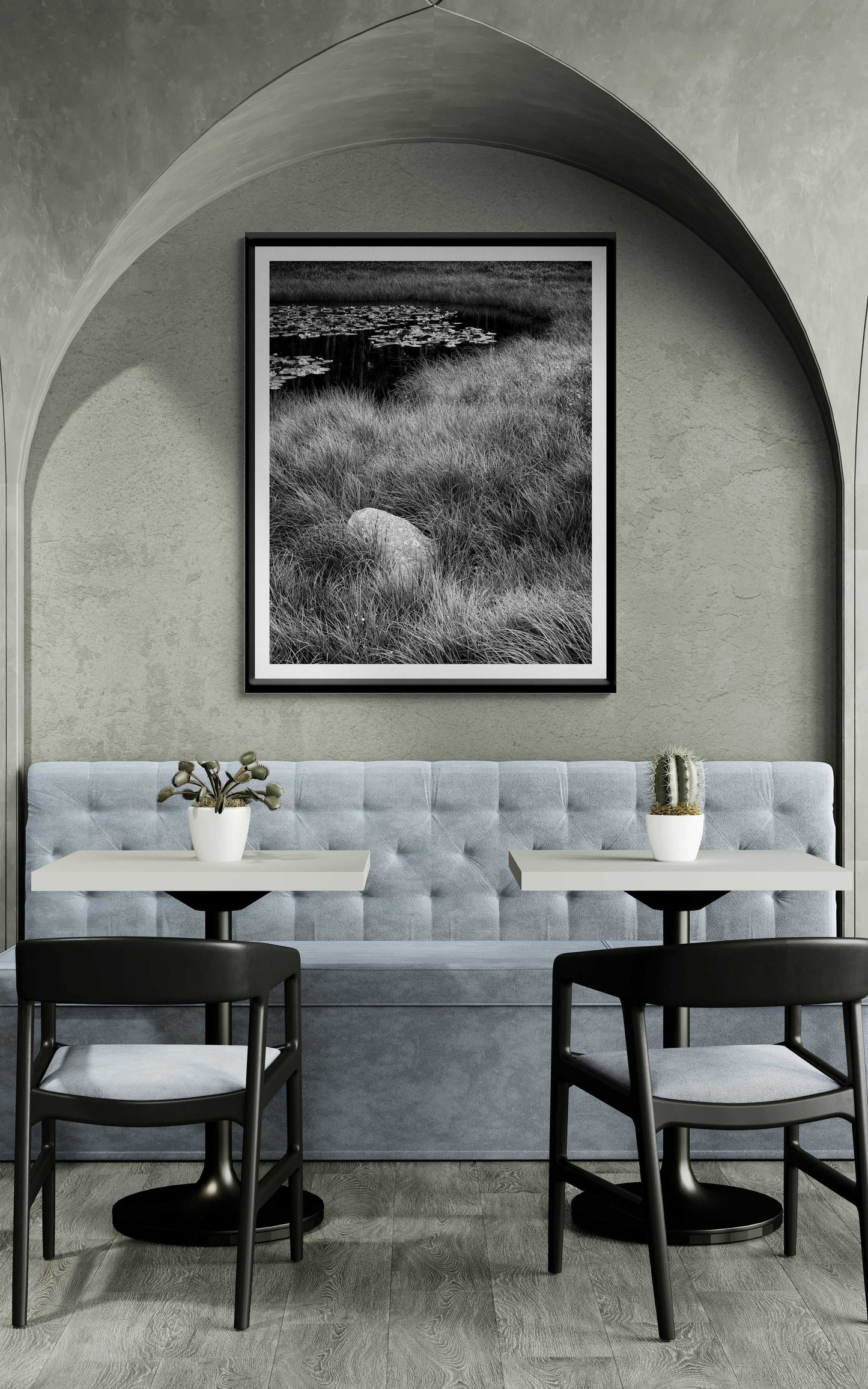 Chic cafe interior with framed 'Pond Boulder' black and white landscape print by Michael Hart, adding calm ambiance to the seating area.