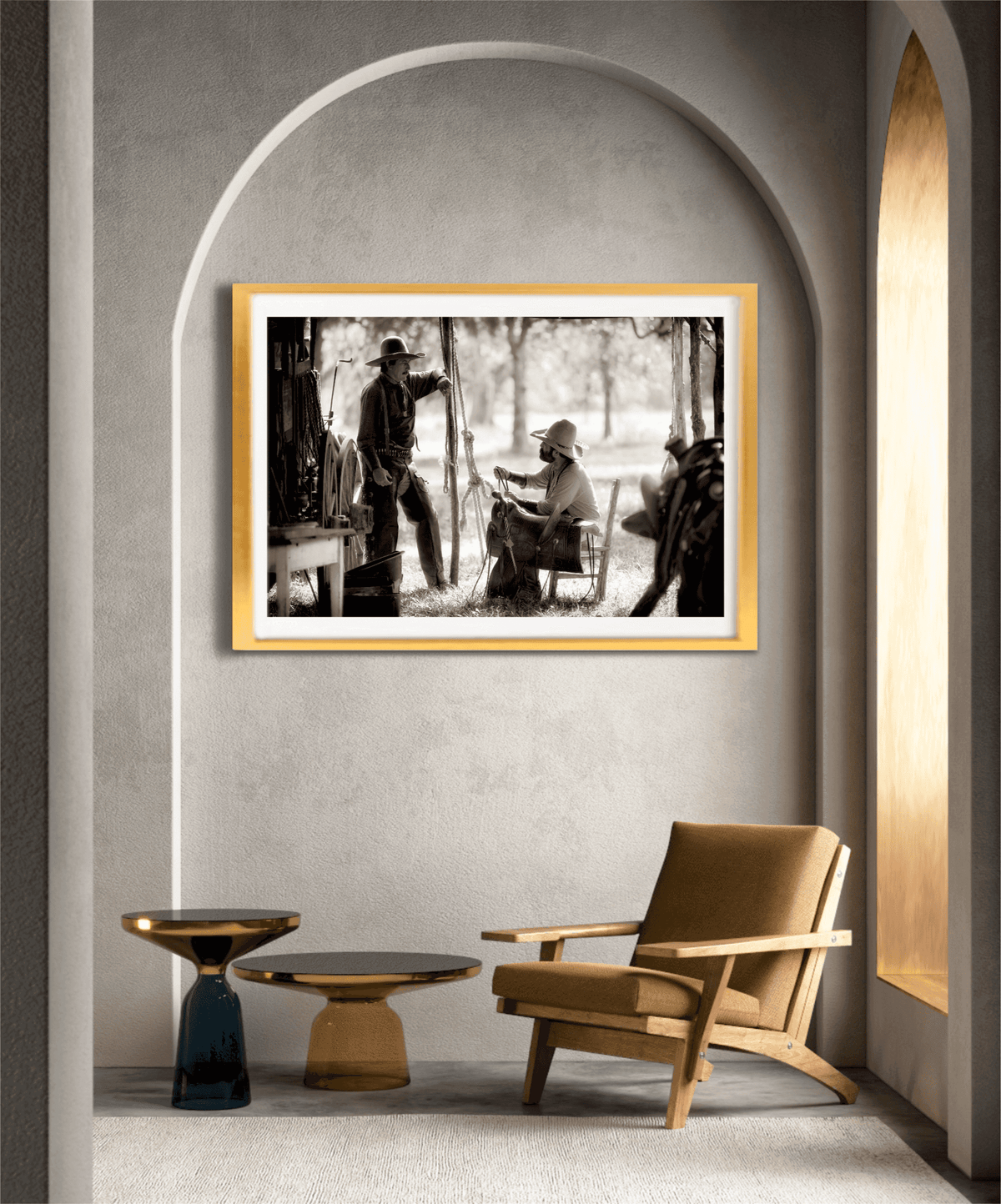 Sepia-toned cowboy heritage artwork 'Camp Talk: A Chuckwagon Cook-Off in Authentic Old West Style' framed in gold and showcased in a modern arched alcove with minimalist furniture.