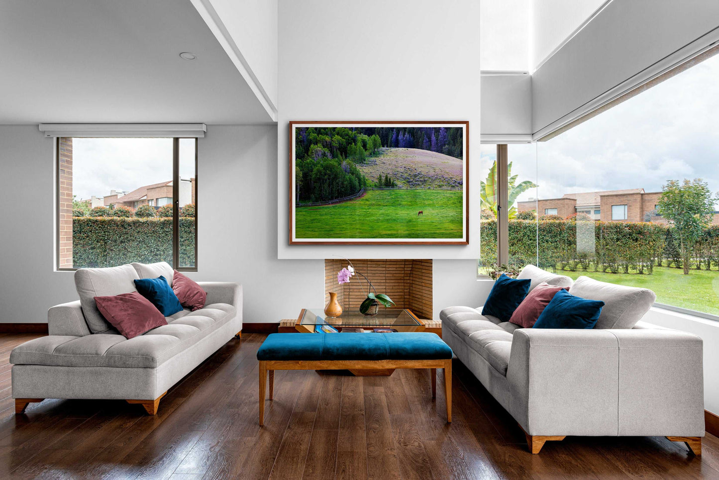 Lone Horse on Gros Ventre Ranch photograph framed above a fireplace in a bright, modern living room with large windows. Perfect for nature-themed or Western-style decor.