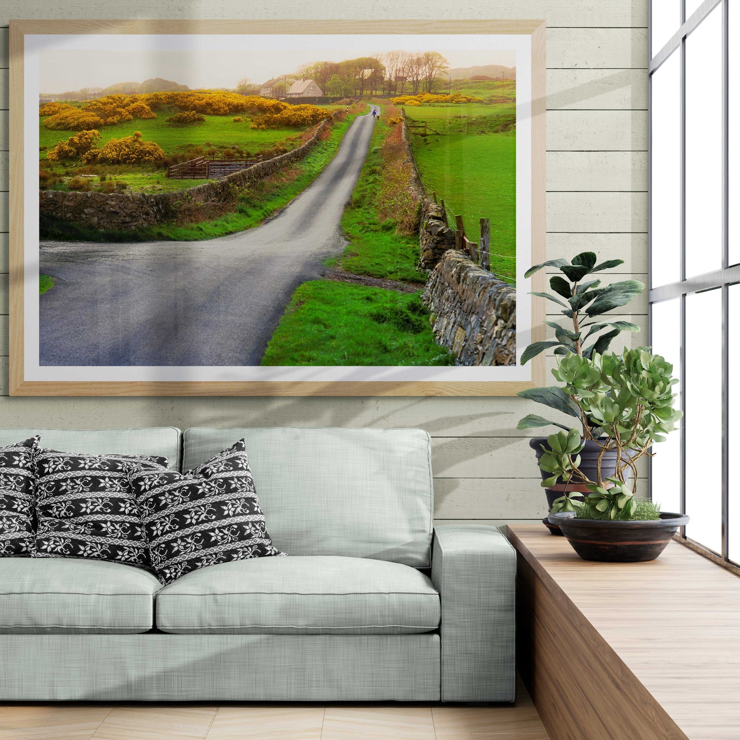 Rush Hour On Islay fine art print in a bright living room, showcasing a scenic whisky isle road with a lass and dog framed by stone walls and fields.