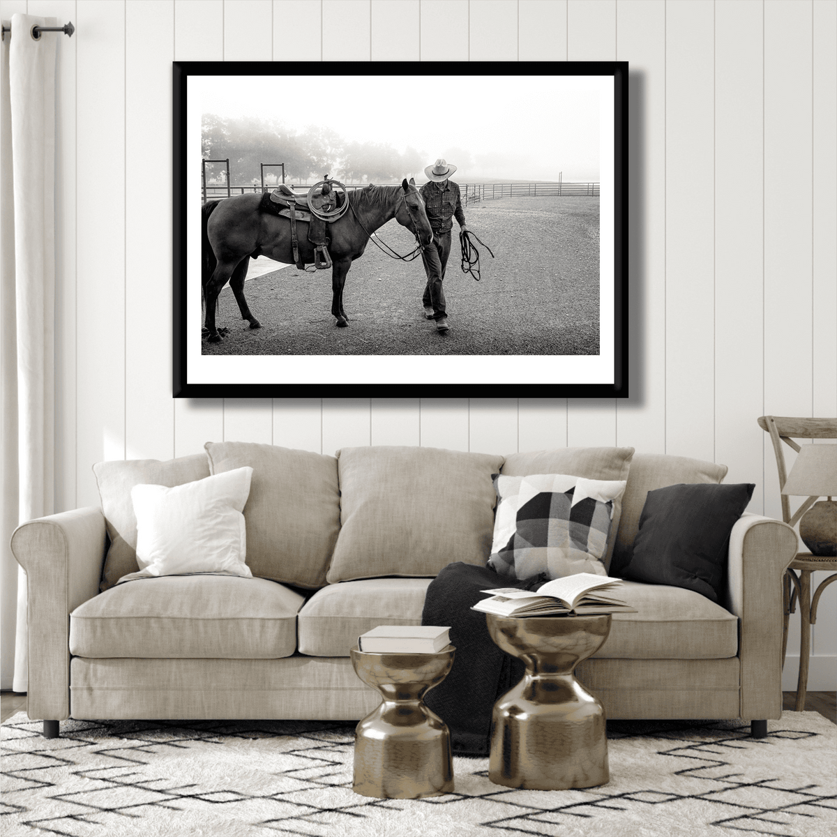 Morning Ride – Saddling Up in the Fog, Black and White Ranch Print by Michael Hart displayed above a beige sofa in a modern living room. Limited edition Texas ranch wall art featuring a cowboy and horse in morning fog.