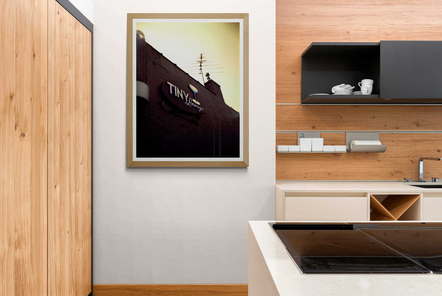 A print of an image, shot on a Holga camera, of the signage at The Tiny Lounge, an iconic small bar that used to exist in Chicago, Illinois, shown on the wall of a room setting