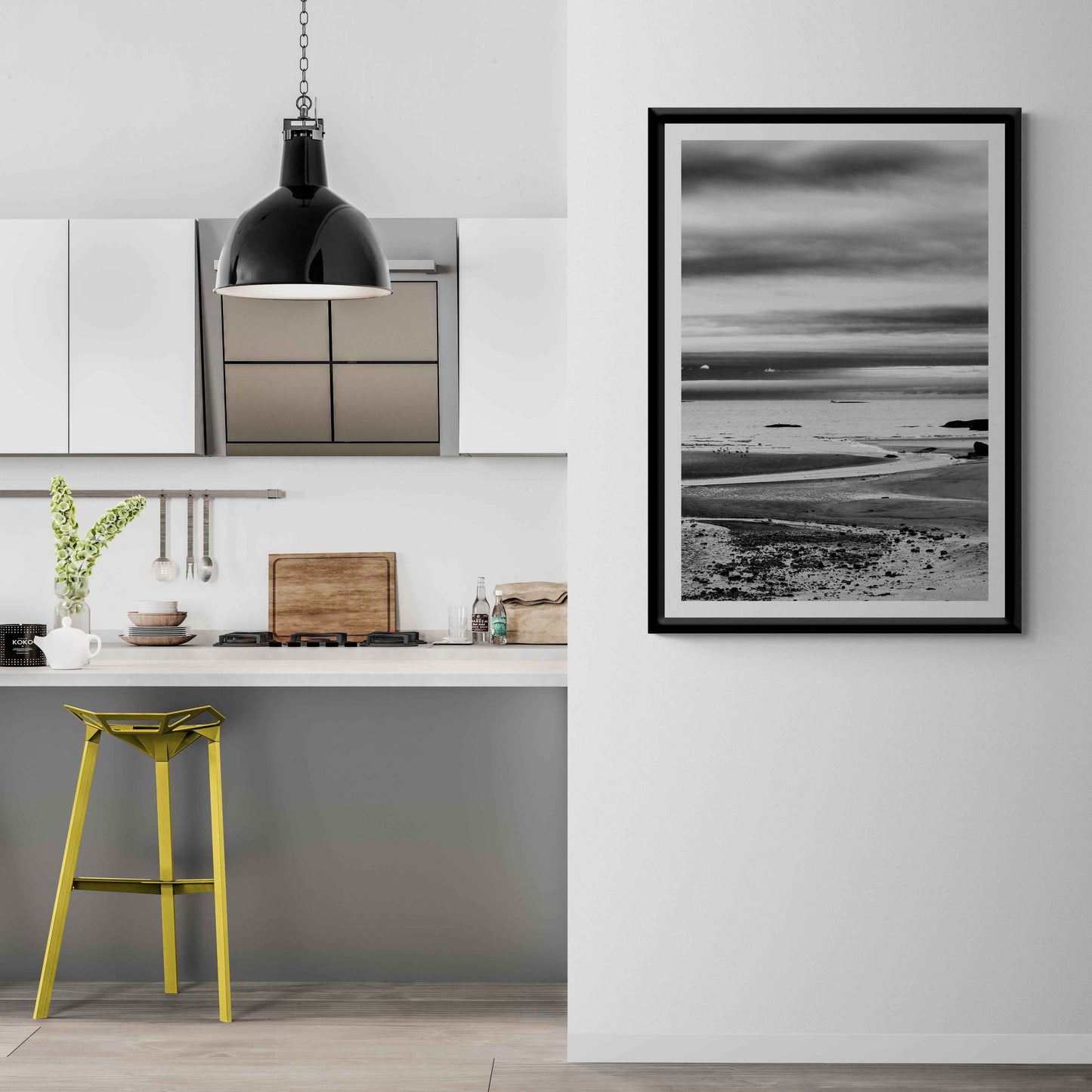 A print of a moody black and white image titled Grey Atlantic #1, moody coastal Maine image shown framed on the wall of a room setting