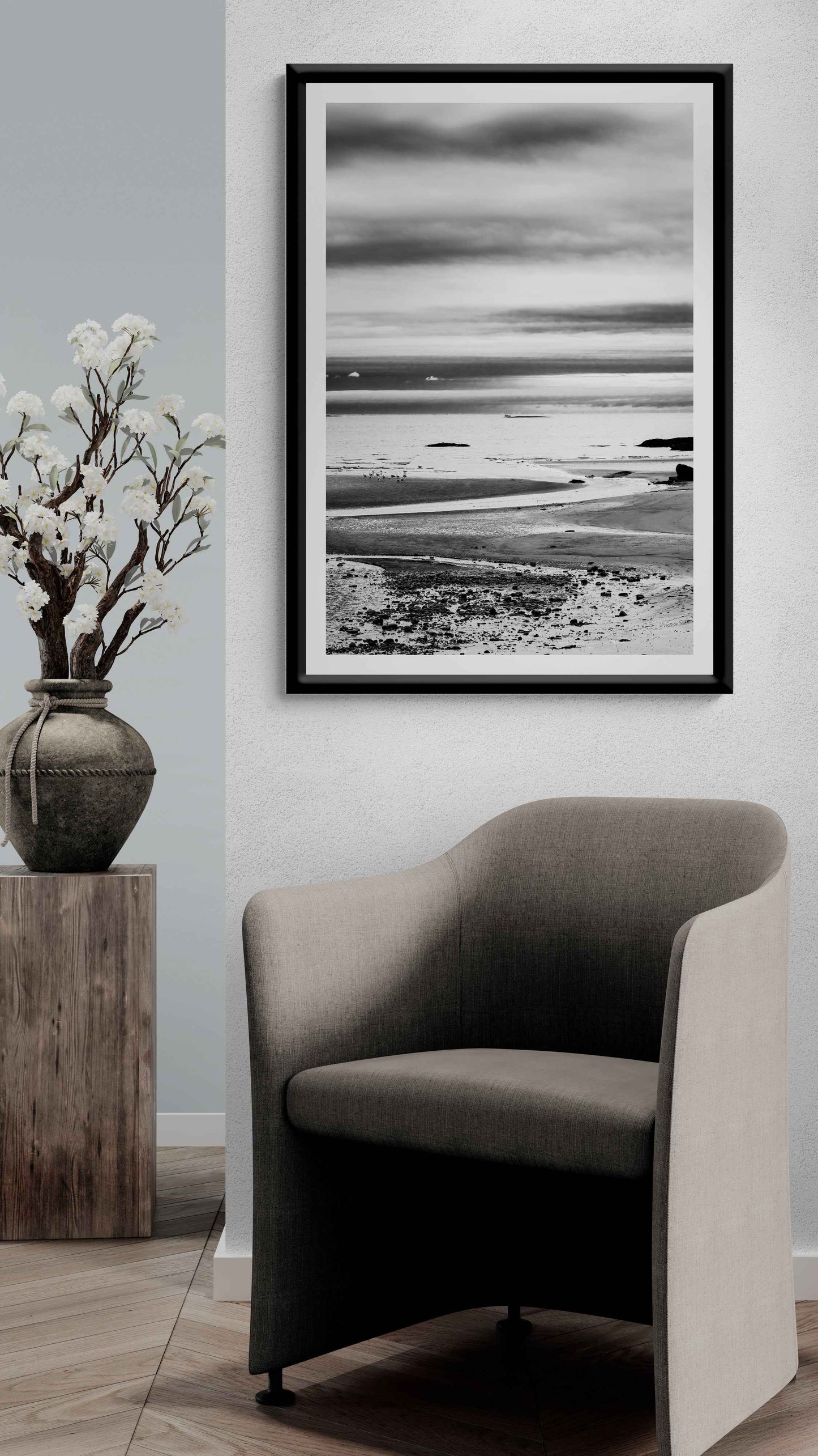 A print of a moody black and white image titled Grey Atlantic #1, moody coastal Maine image shown framed on the wall of a room setting
