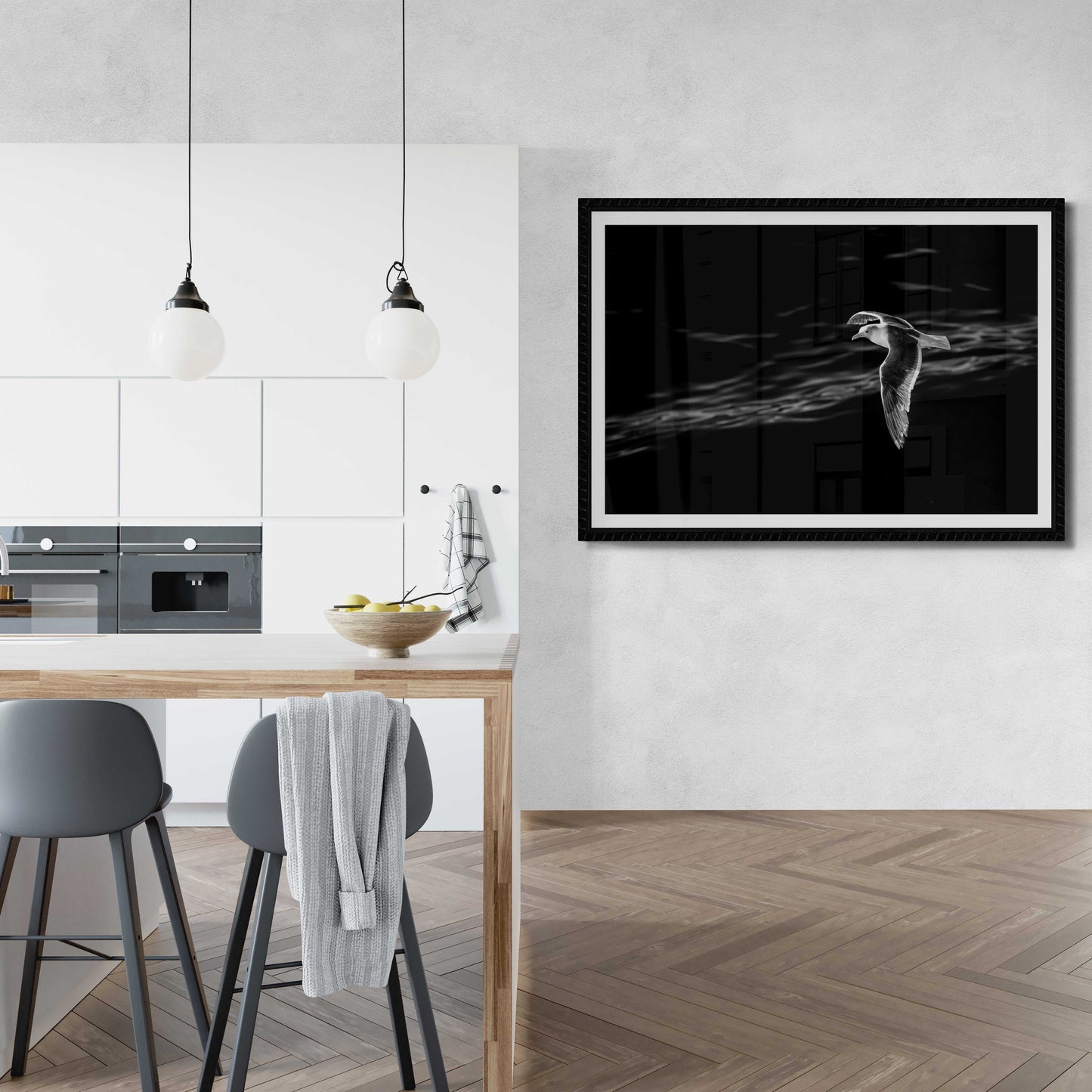 Graceful Flight – A Seagull Over Puget Sound in Black & White fine art print displayed in a sleek kitchen-dining area, ideal for minimalist wall decor.