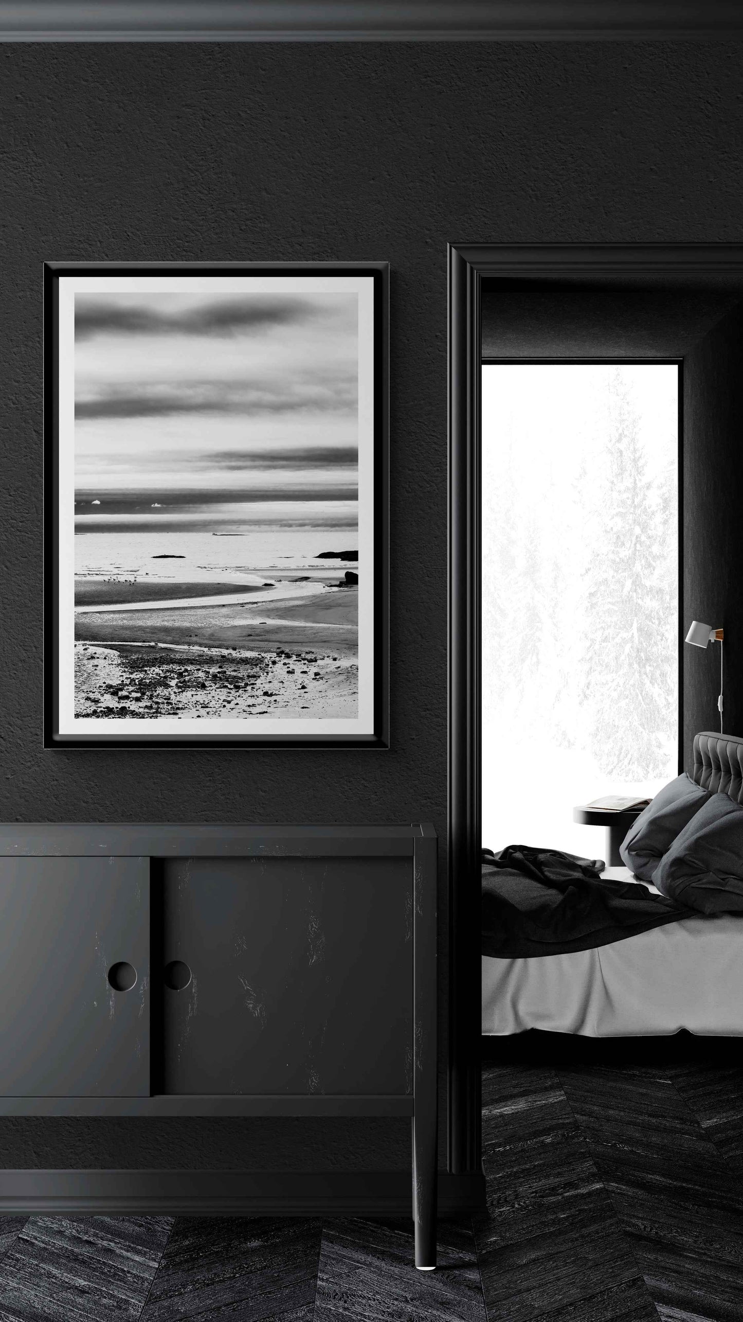 A print of a moody black and white image titled Grey Atlantic #1, moody coastal Maine image shown framed on the wall of a room setting