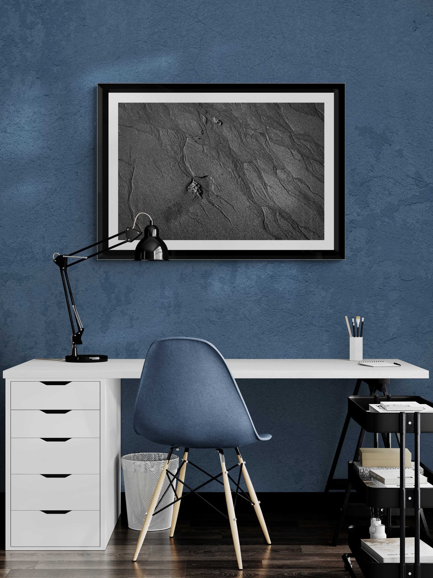 Traces #2 black and white sand etching artwork framed above a white desk in a blue-toned home office. Perfect for serene workspace design.