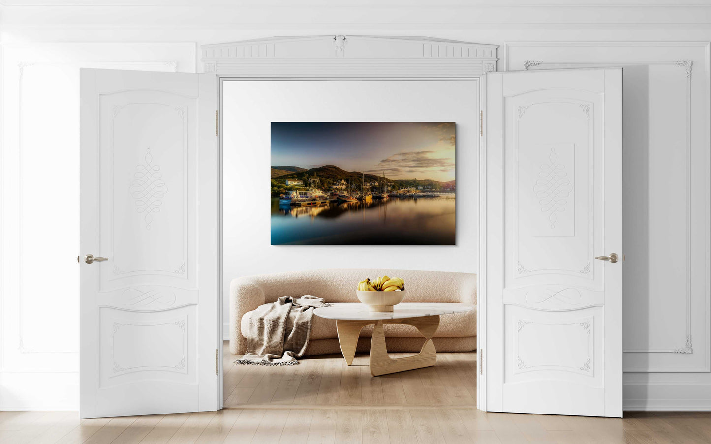 Golden Light over Kyleakin Harbor – Isle of Skye landscape image by Michael Hart displayed in a modern white living room above a beige sofa. The fine art print captures a peaceful harbor scene with golden hour reflections, ideal for interior design and home decor.