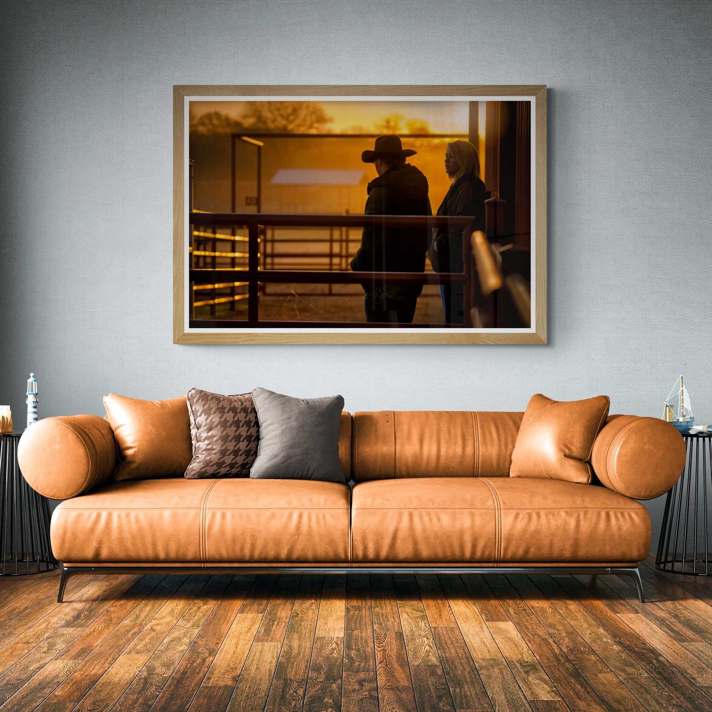 Golden hour cowboy art print Corral Sunrise displayed in a cozy Western-themed living room with leather furniture and rustic wood flooring.