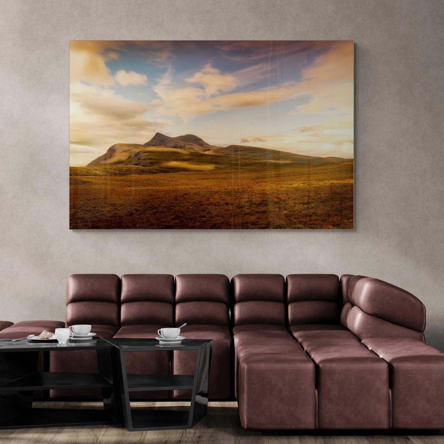 Large Cùl Mòr wall art print above a leather sectional in a modern living room, highlighting Scotland’s North Coast 500 mountain scenery.