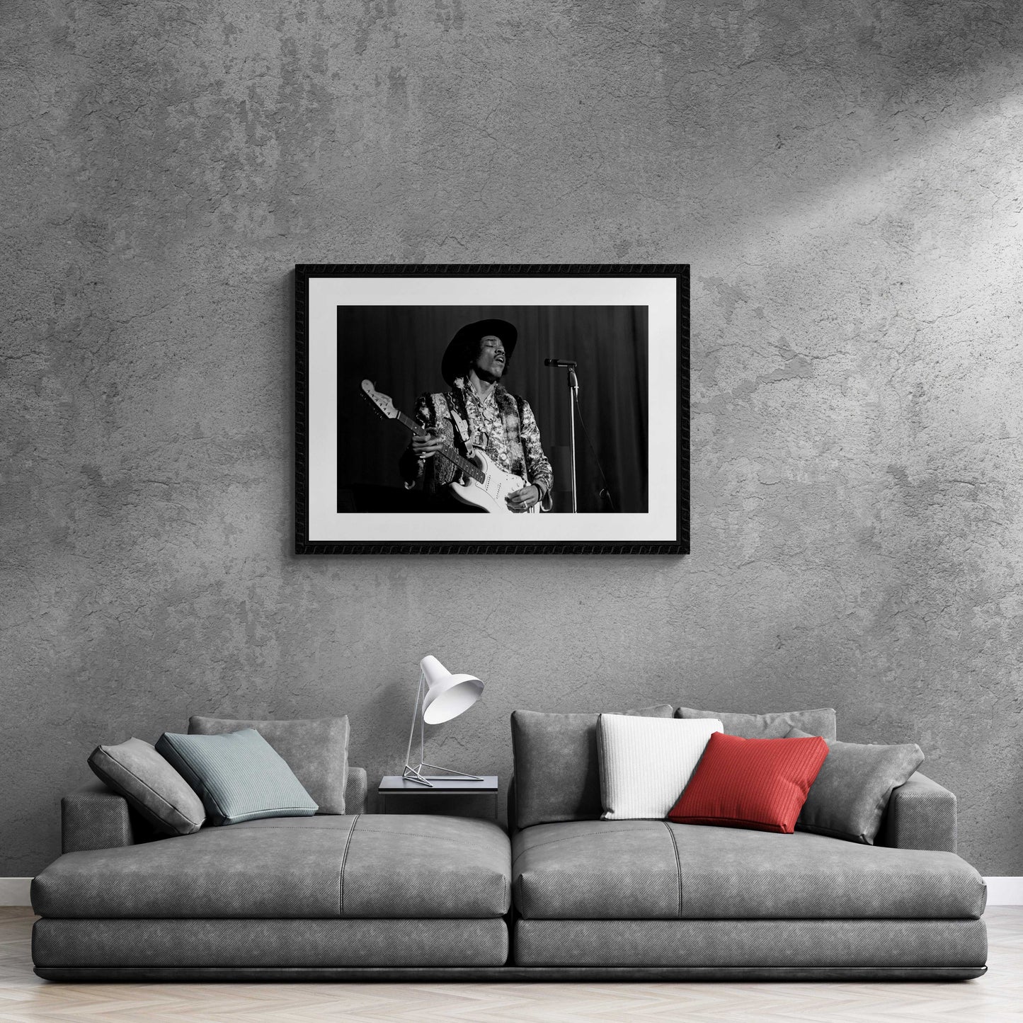 Stylish living room with framed Jimi Hendrix black and white concert photo above grey sofa. Perfect for music-inspired interior design.