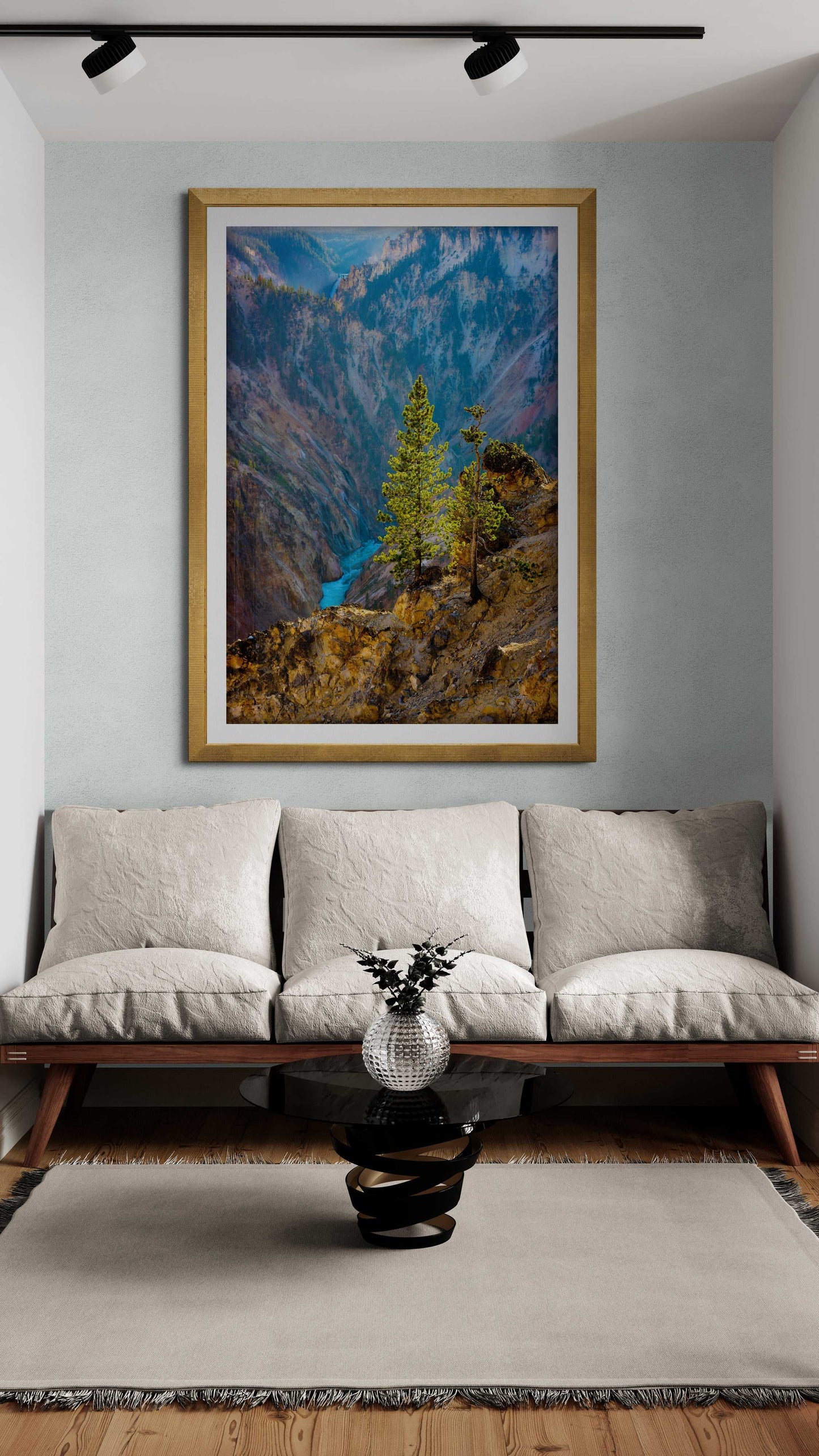 Framed fine art print of a lone tree over Yellowstone River displayed above a modern beige sofa. Ideal for home decor and interior design art.