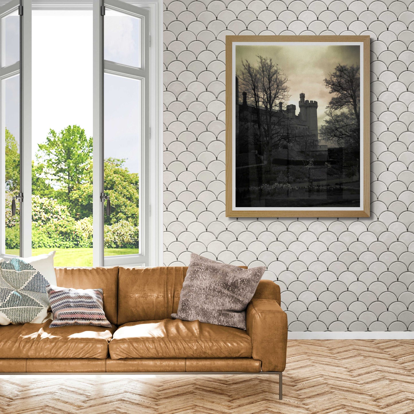 A framed print of Arundel Castle, in Sussex, England, on the wall in an airy room setting.