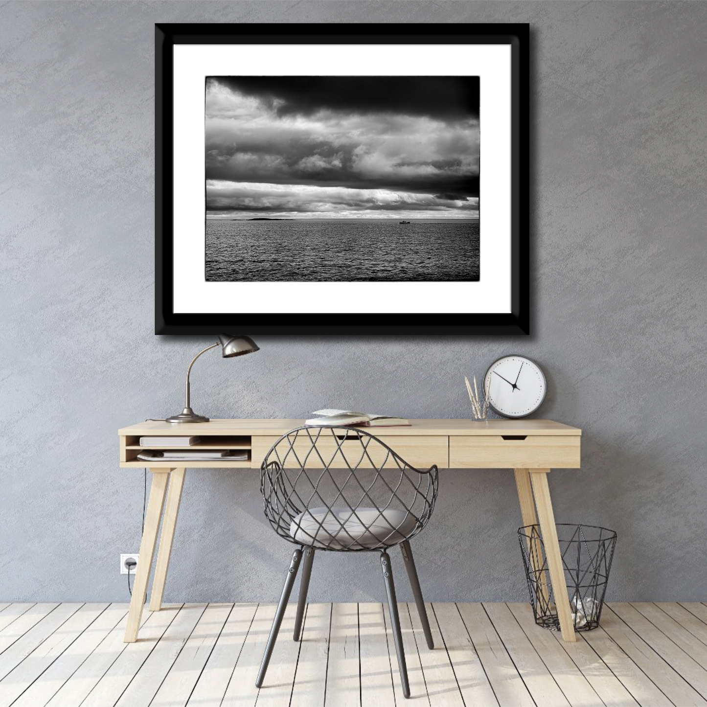 Framed black and white seascape photograph of the Atlantic Ocean at Marshall Point, Maine displayed above a minimalist home office desk