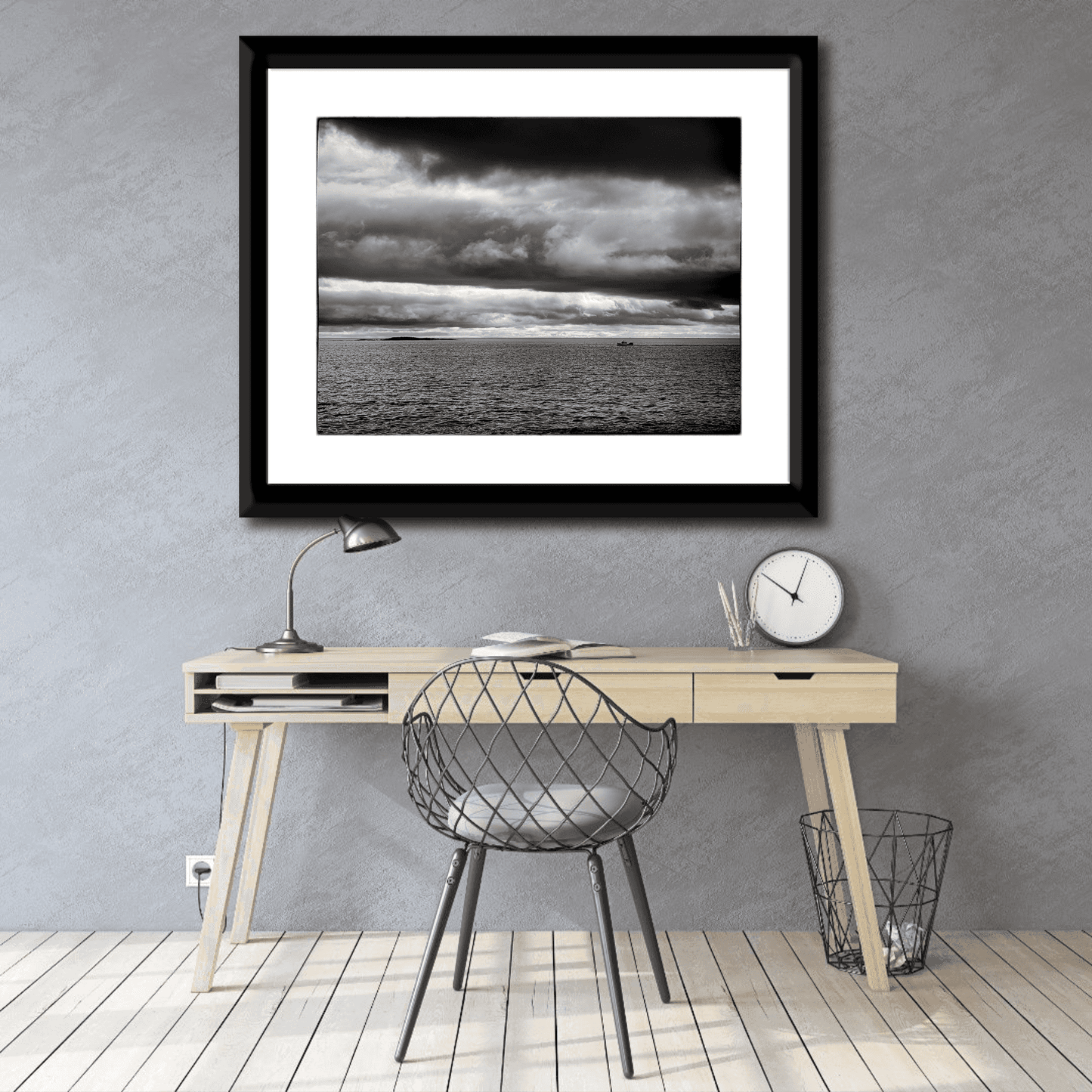 Framed black and white seascape photograph of the Atlantic Ocean at Marshall Point, Maine displayed above a minimalist home office desk