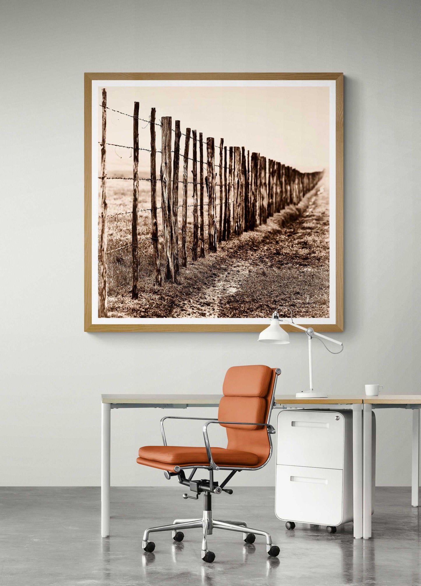 Framed Eight Miles from Nowhere: Fence Line in the Fog, 44 Farms artwork displayed above a modern desk setup. Ideal for rustic office decor.