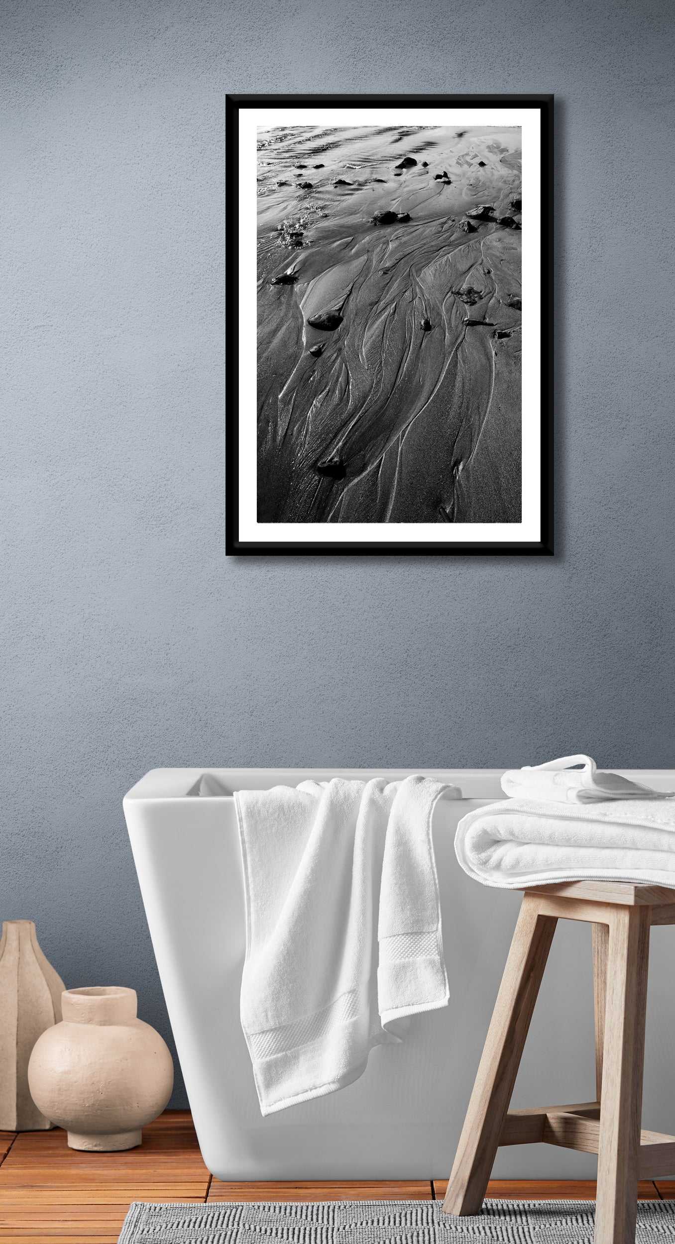 Black and white sand pattern artwork 'Traces #3' displayed in a modern bathroom, adding minimalist coastal elegance to home decor.