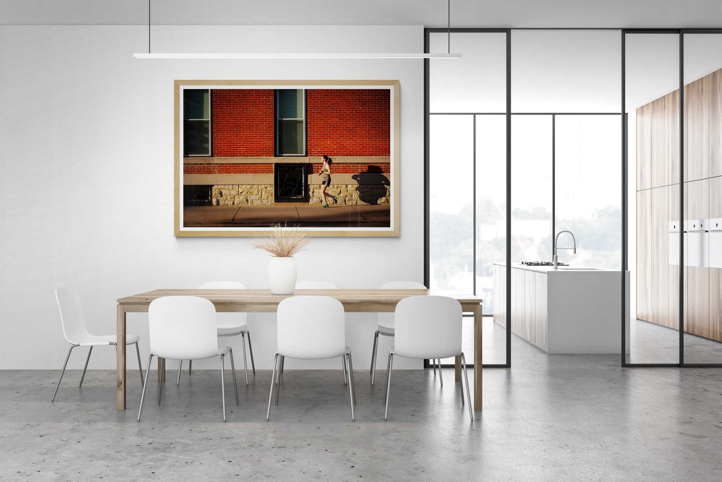 Framed print in a rooms setting of woman jogging along a sidewalk in Chicago, in the early evening summer light, against. red brick facade.