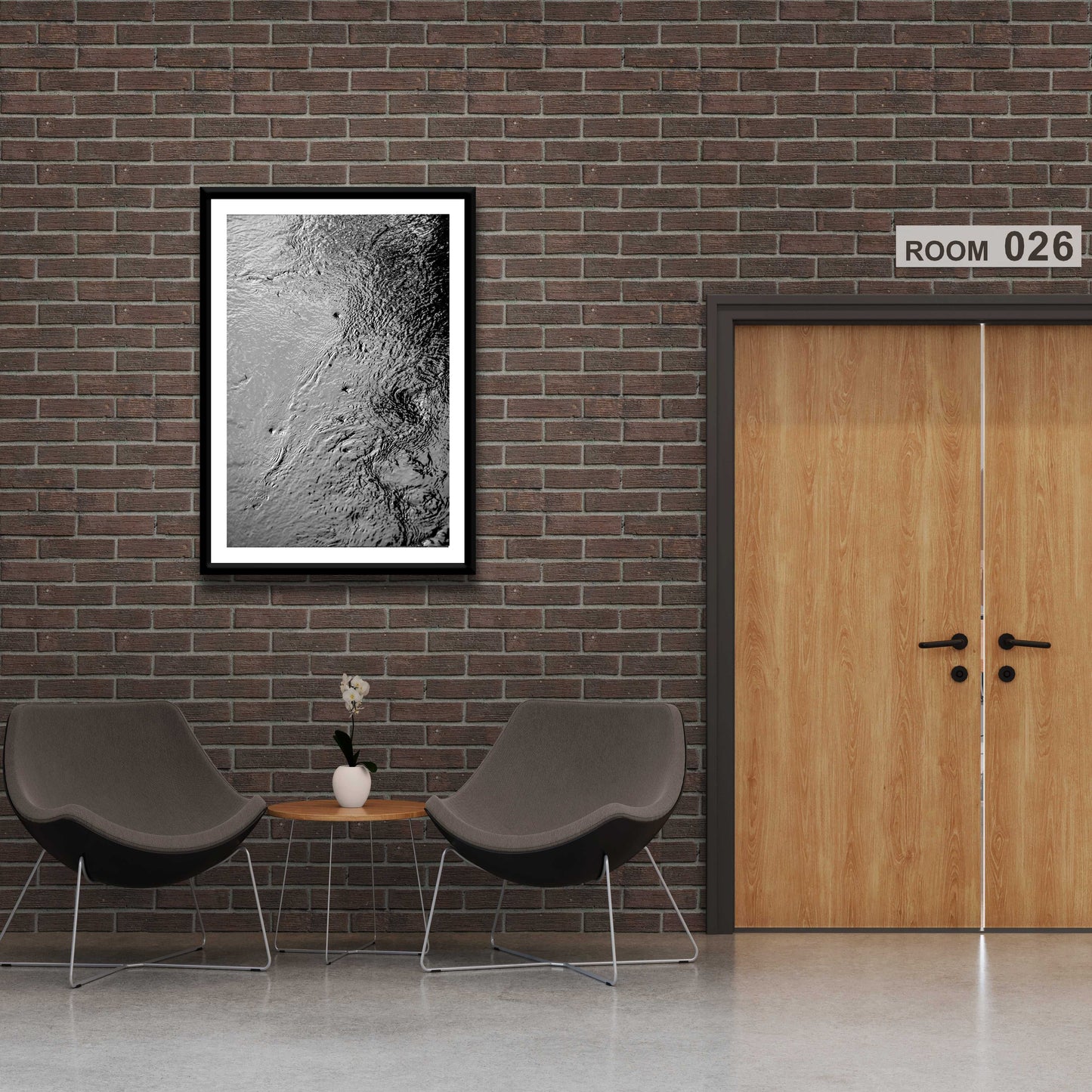 Traces #5 – Currents and Whirlpools in a Maine Stream – Black & White Nature Photography framed and displayed in a modern office waiting area with brick walls.